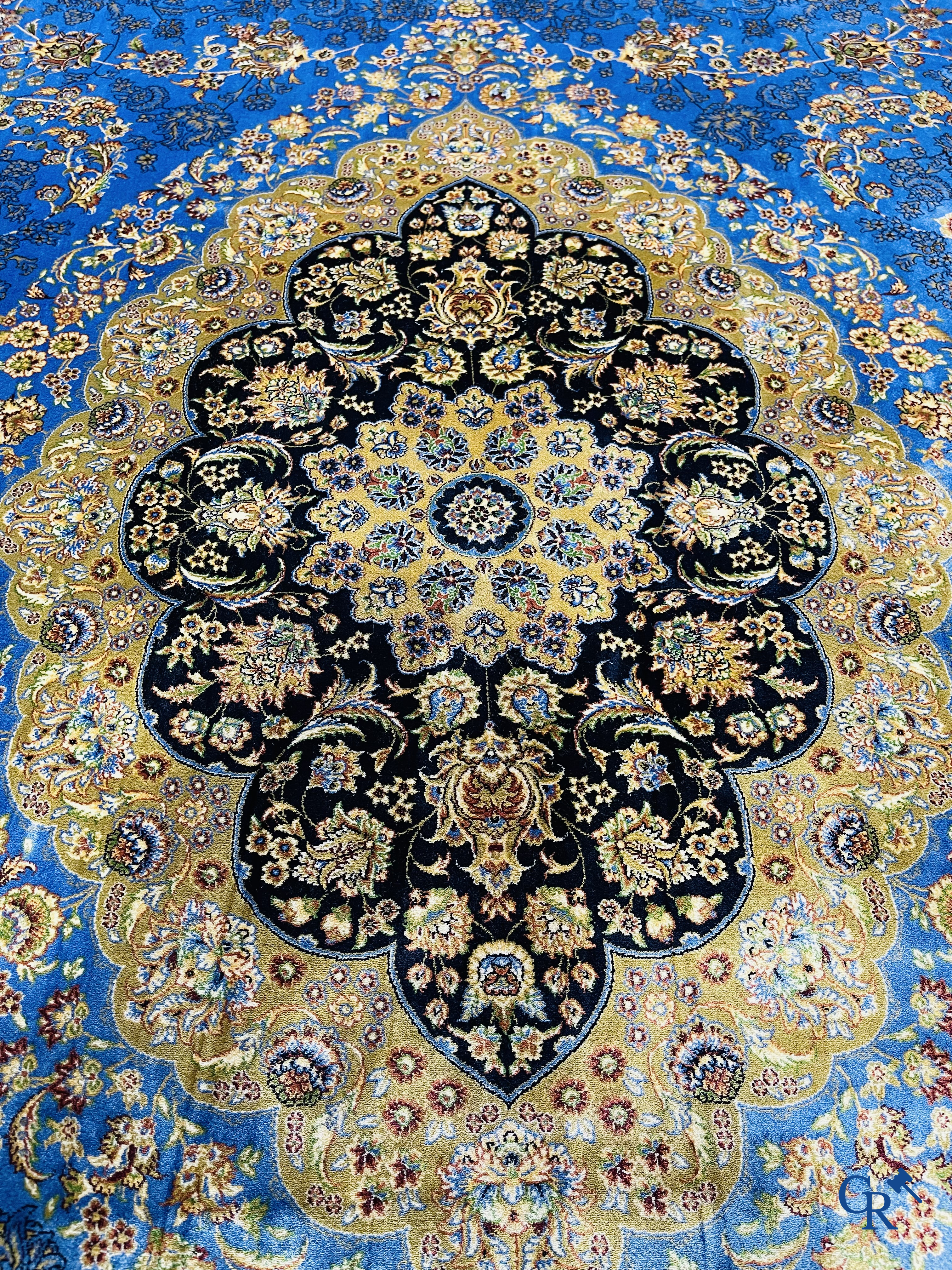 Tapis. Exceptionnel tapis en soie avec un décor floral sur fond bleu.