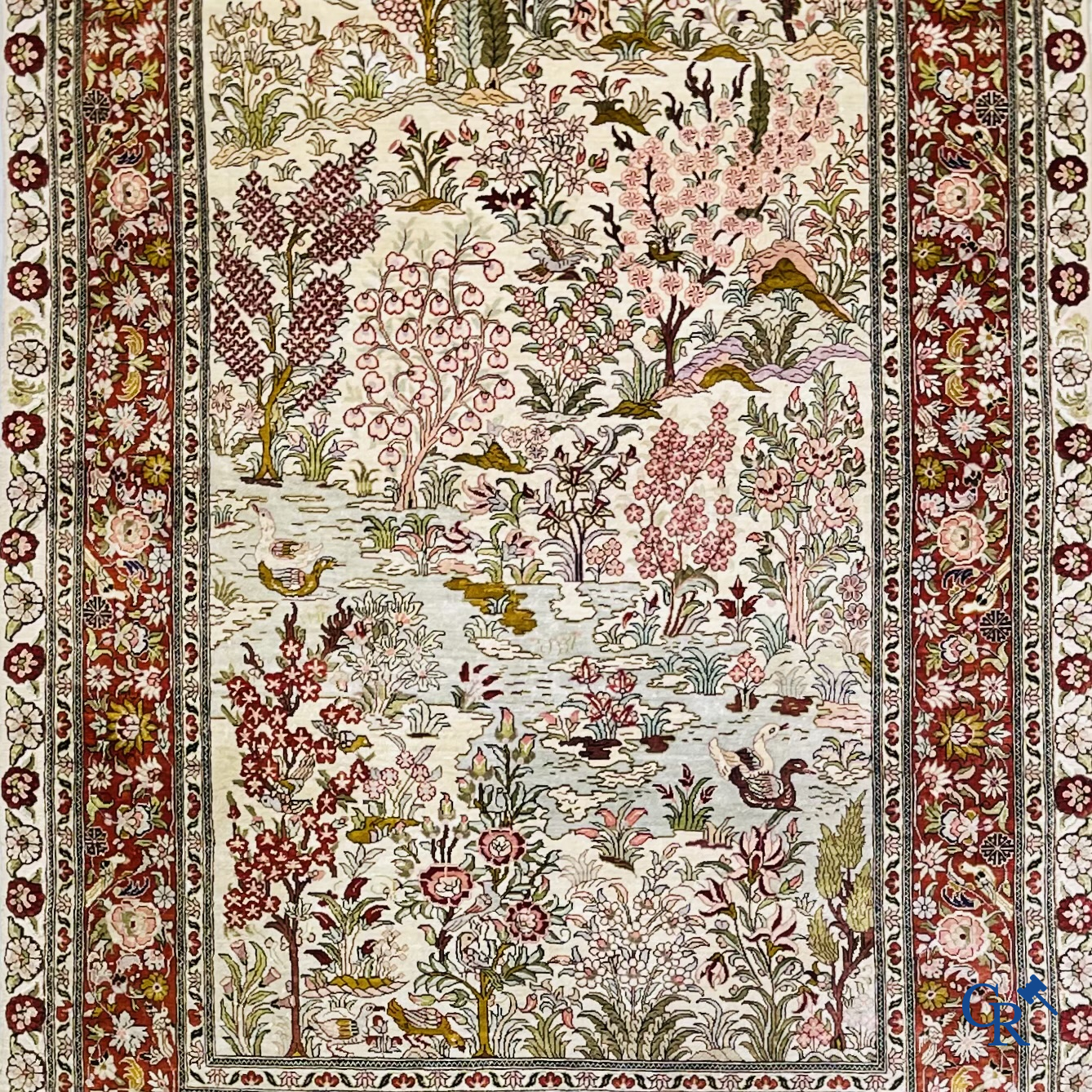 Oriental carpets: A finely hand-knotted silk carpet with water birds in a landscape on a floral background.