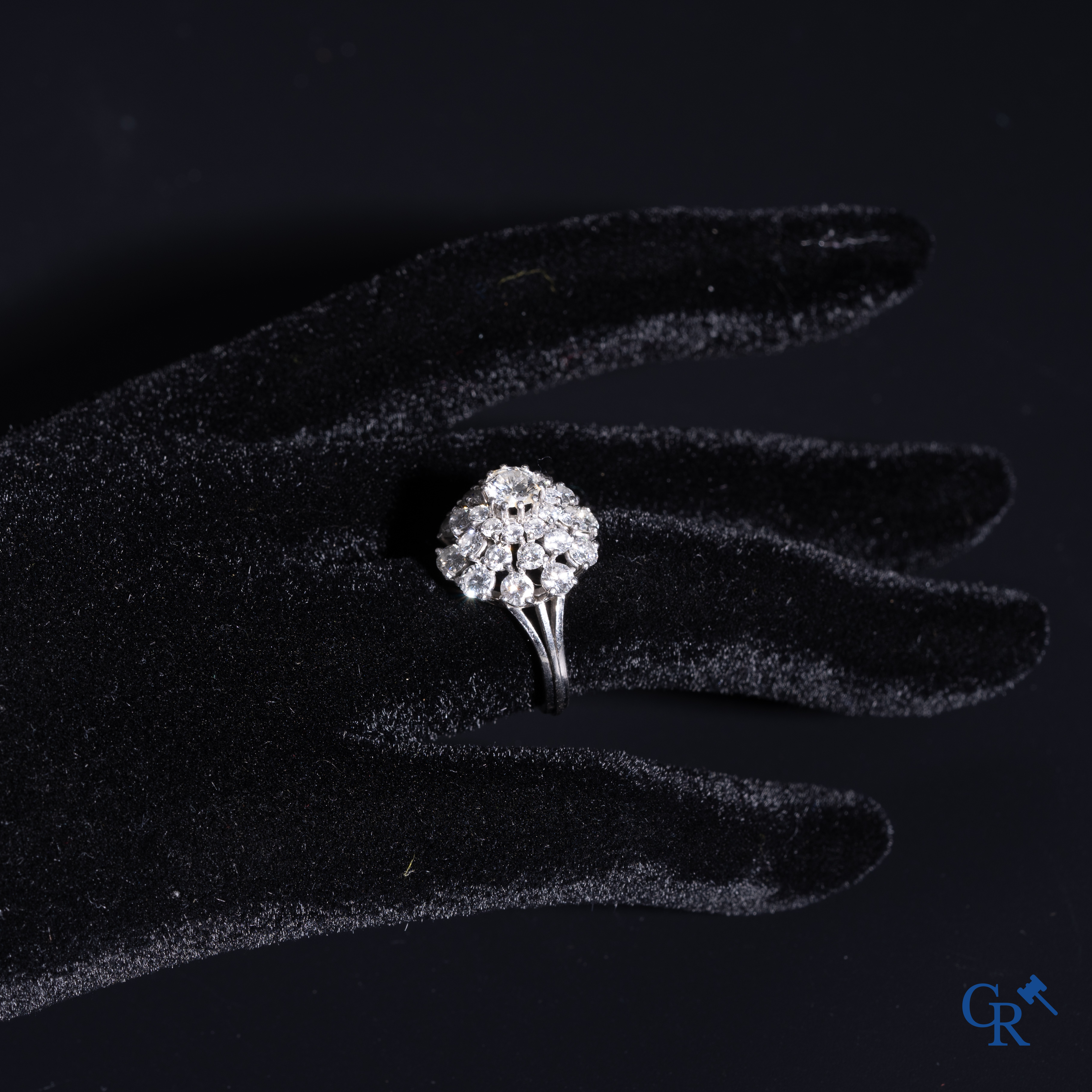 Juwelen: Pompadour ring in Platinum bezet met een centrale diamant van ongeveer 0,75 ct en 30 kleine diamantjes.