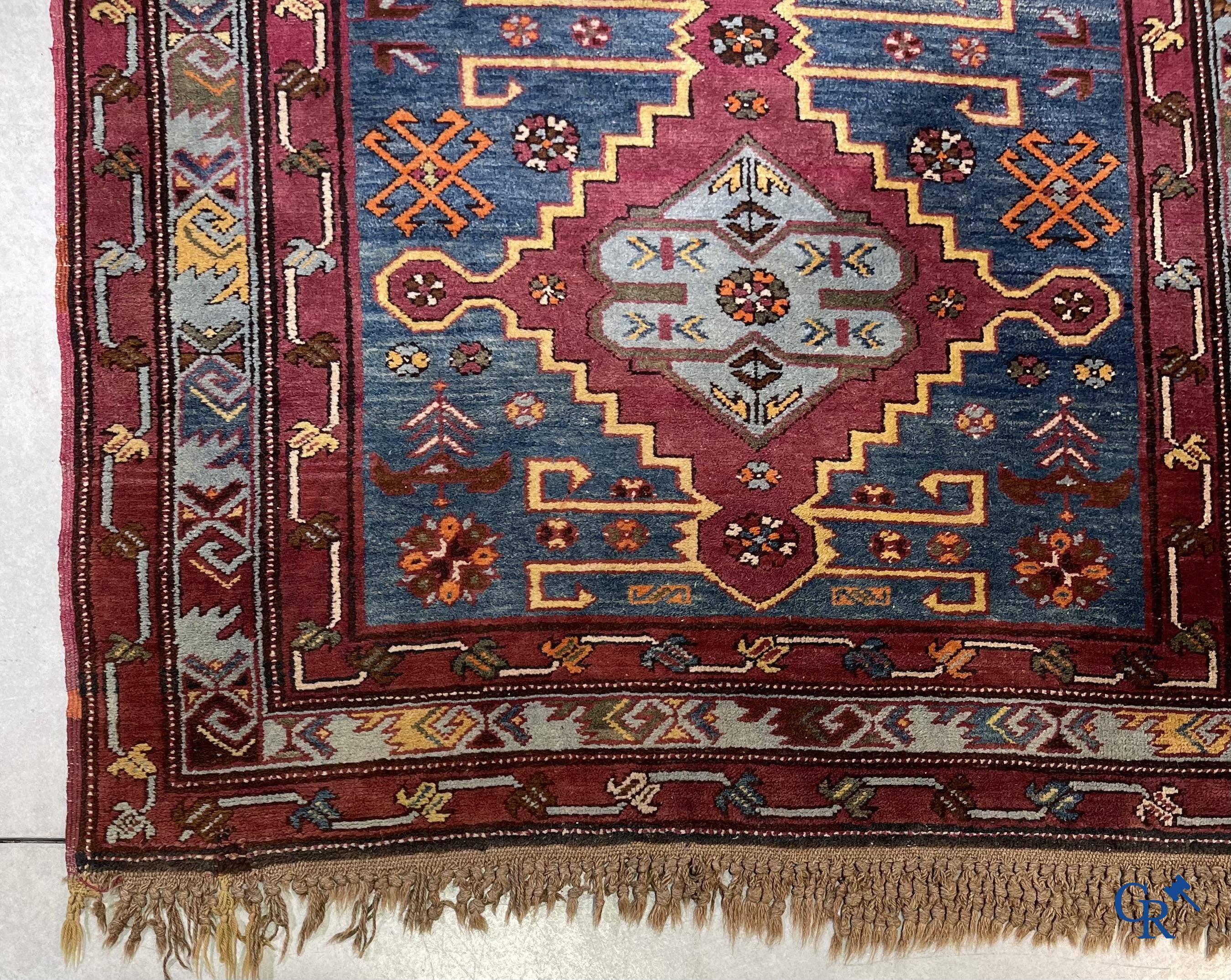 Oriental carpets, an antique hand-knotted Oriental carpet with motifs on a blue background.