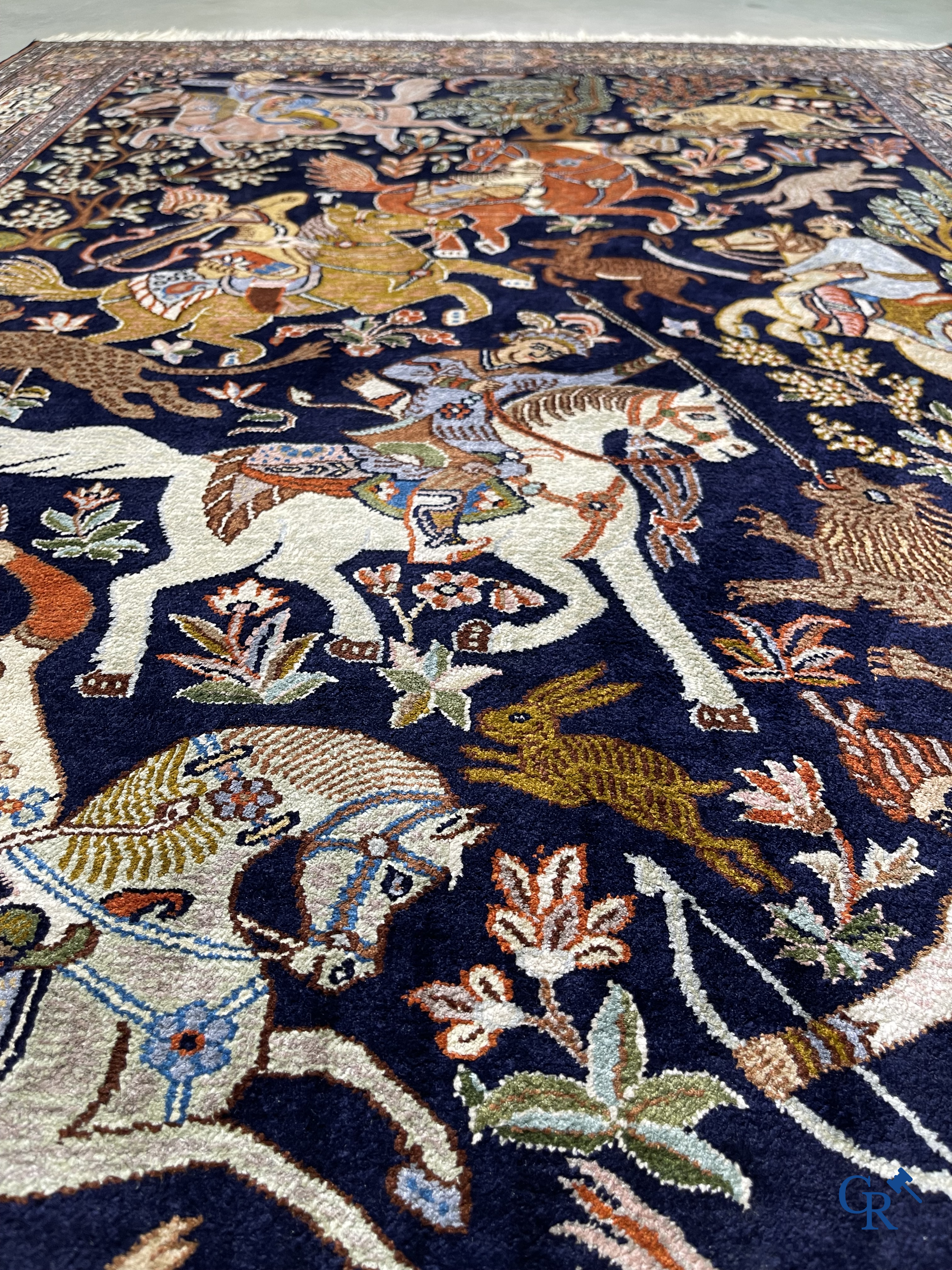 Oriental rugs. Iran. A finely hand-knotted Persian rug in wool and silk with hunters on horseback and inscriptions.