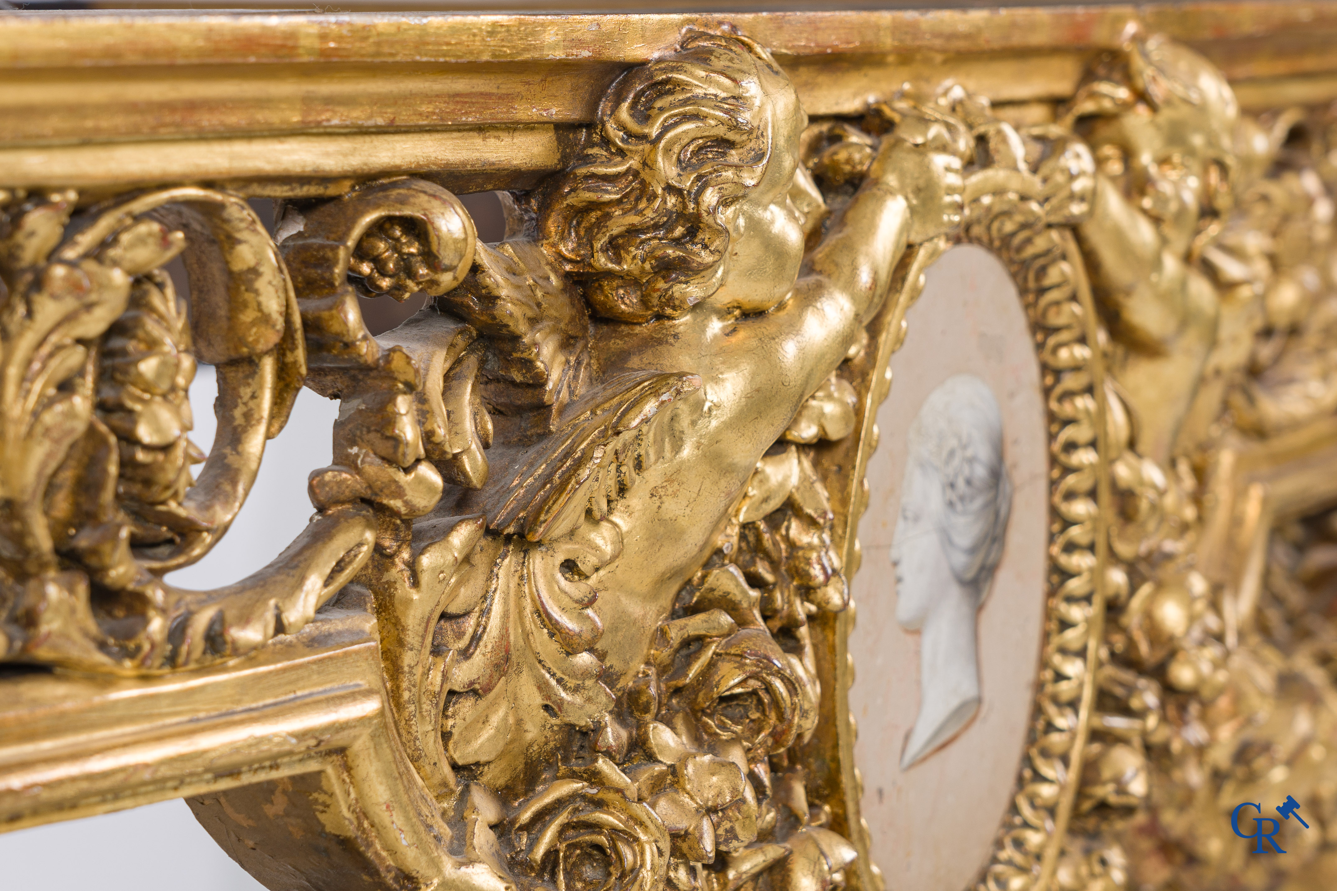 A richly carved and gilded console table in LVXI style with a grisaille painting on marble.