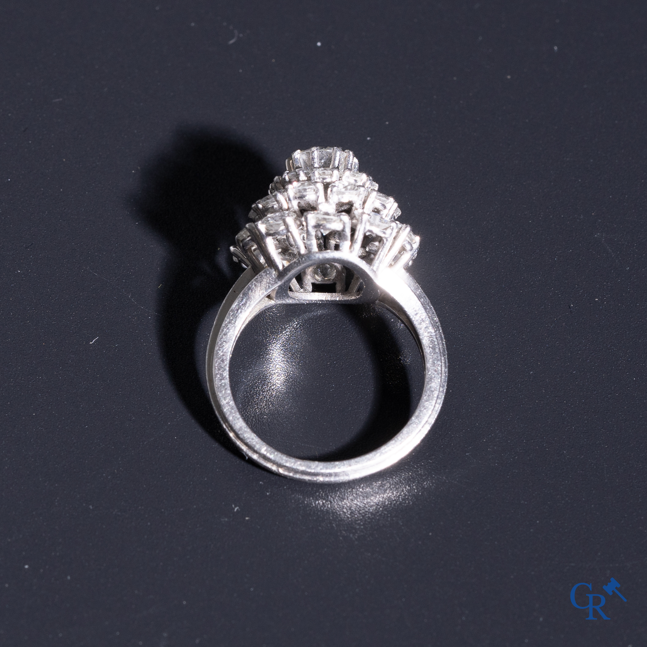 Juwelen: Pompadour ring in Platinum bezet met een centrale diamant van ongeveer 0,75 ct en 30 kleine diamantjes.