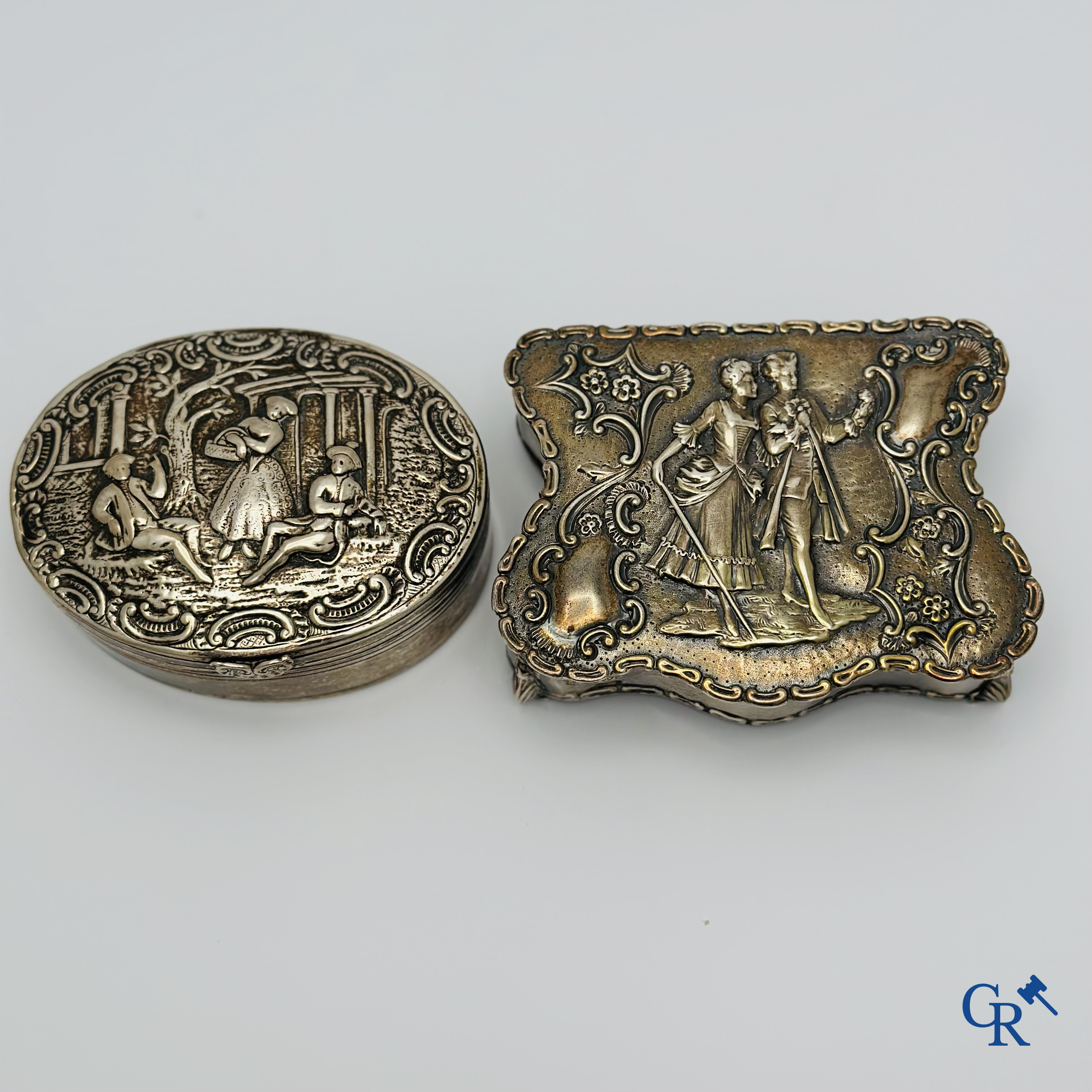 Argent: 2 boîtes en argent avec décor de personnages. Plusieurs poinçons.<br />
Poids total: 340 g.