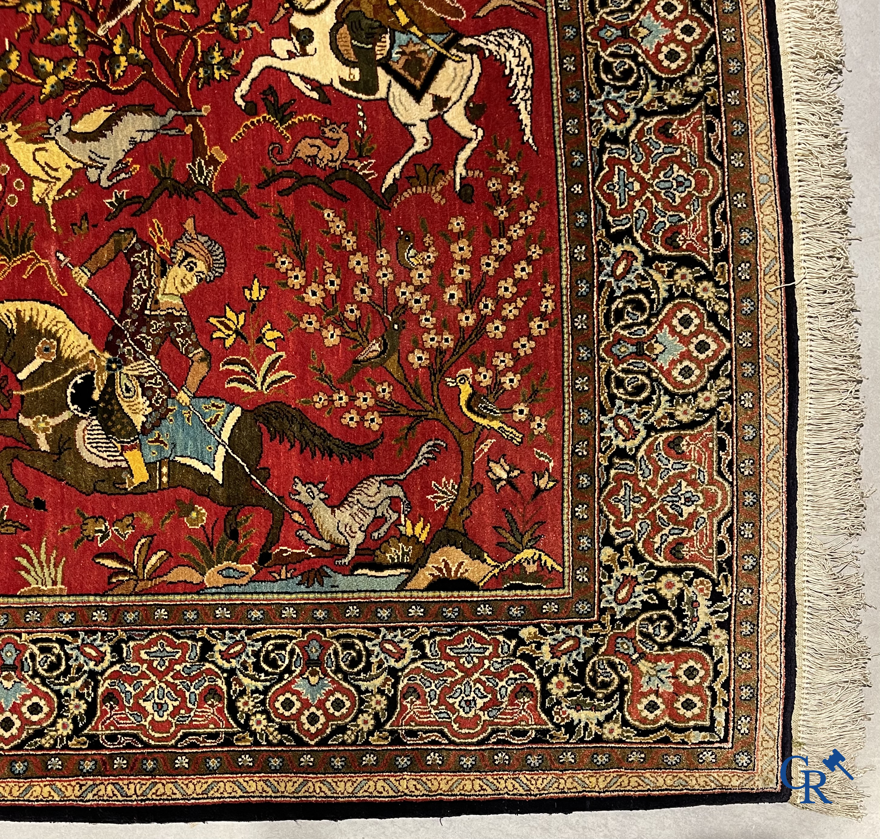 Oriental carpets, a Persian carpet in silk with a scene of hunters on horseback.