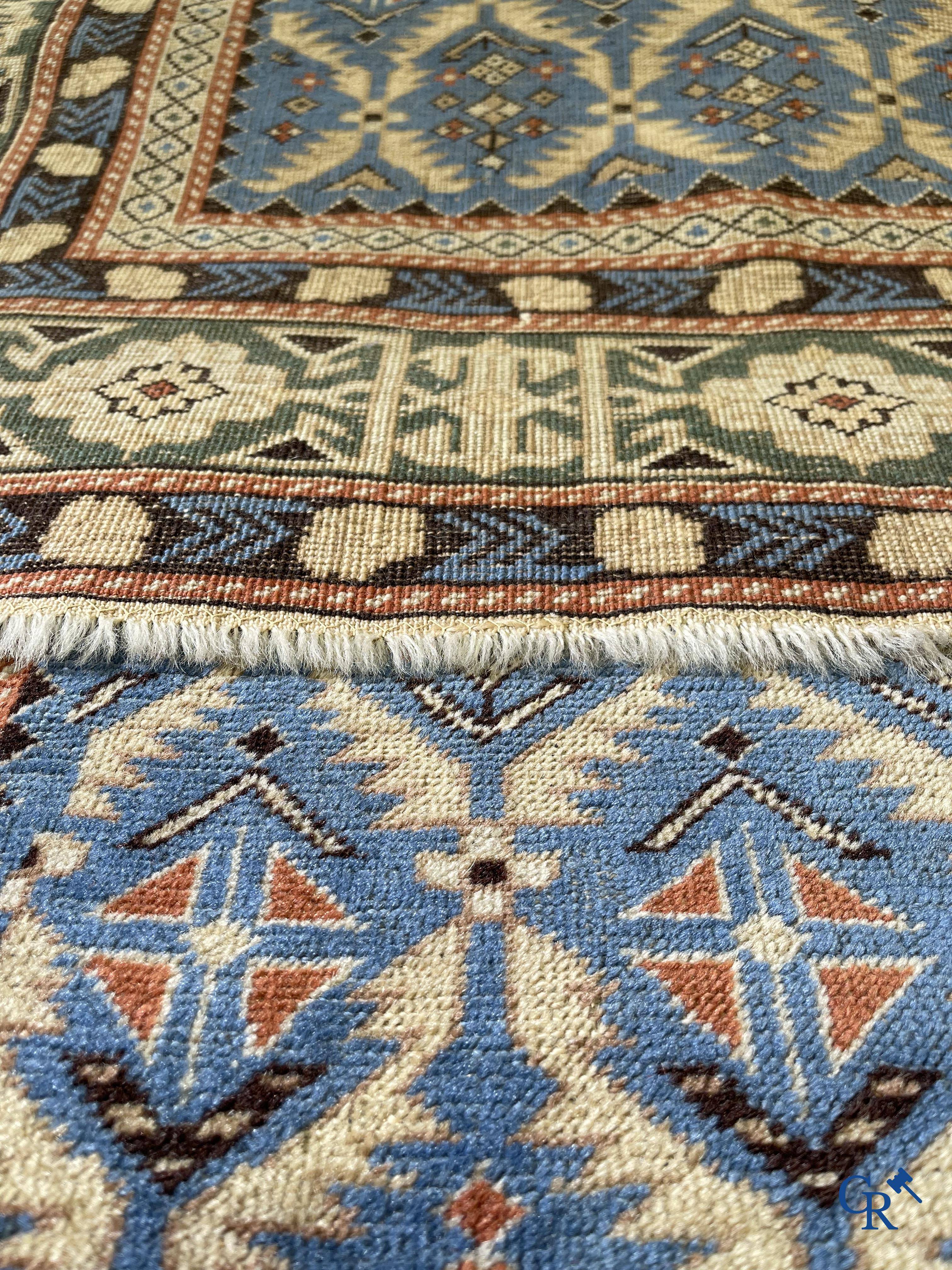 Antique Oriental carpets, an antique Dagestan carpet with motifs on a blue background.