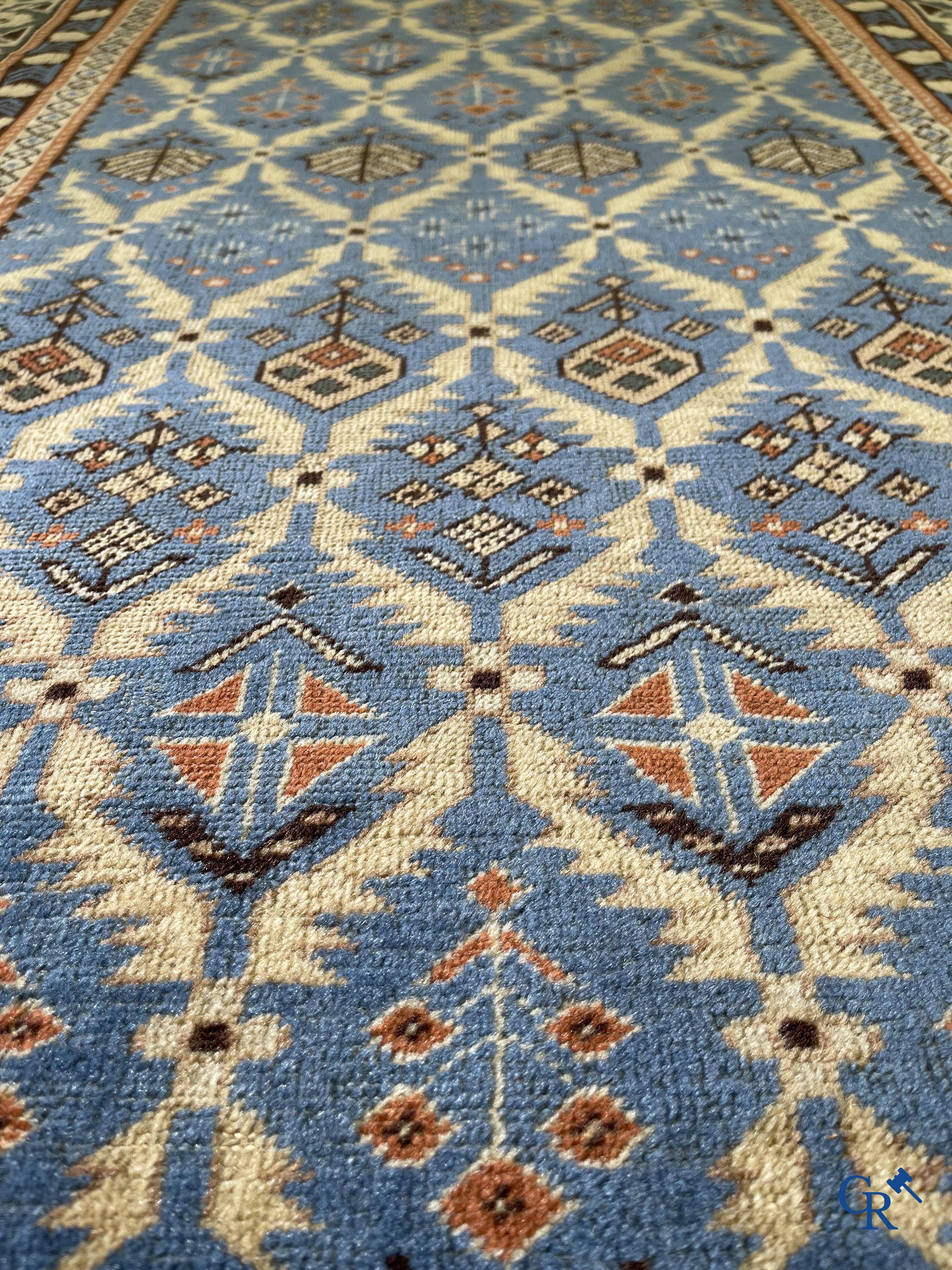 Antique Oriental carpets, an antique Dagestan carpet with motifs on a blue background.