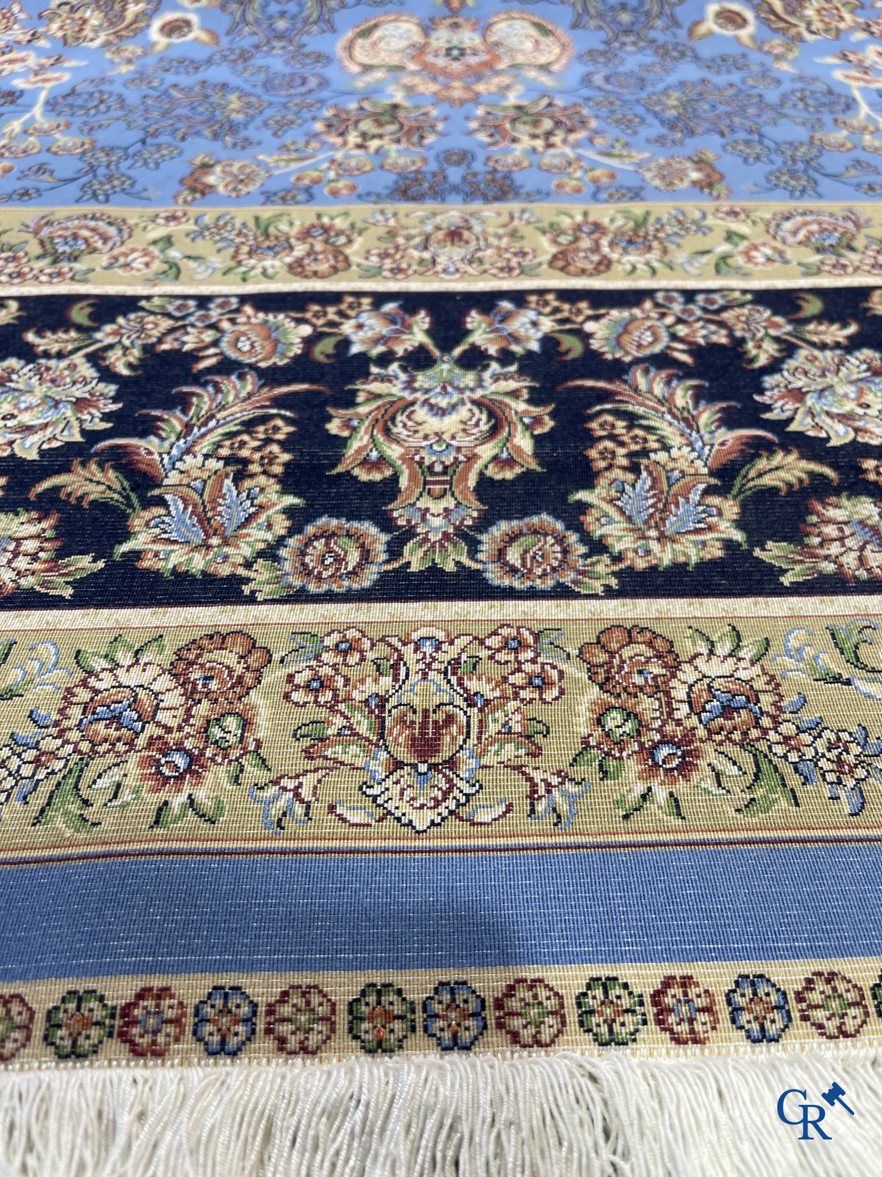 Tapis. Exceptionnel tapis en soie avec un décor floral sur fond bleu.