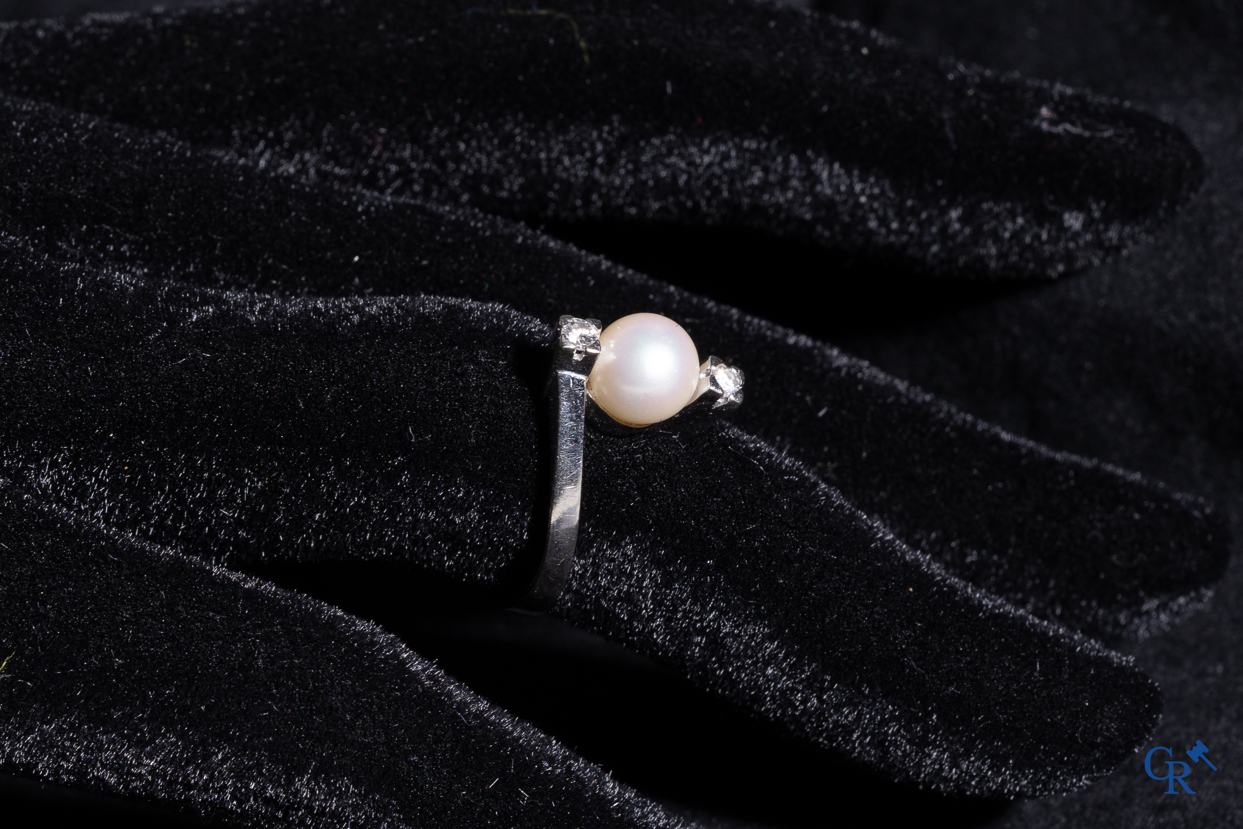 Bijoux: Une bague et une paire de boucles d'oreilles en or blanc 18K (750°/00) serties chacune d'une perle et de diamants.