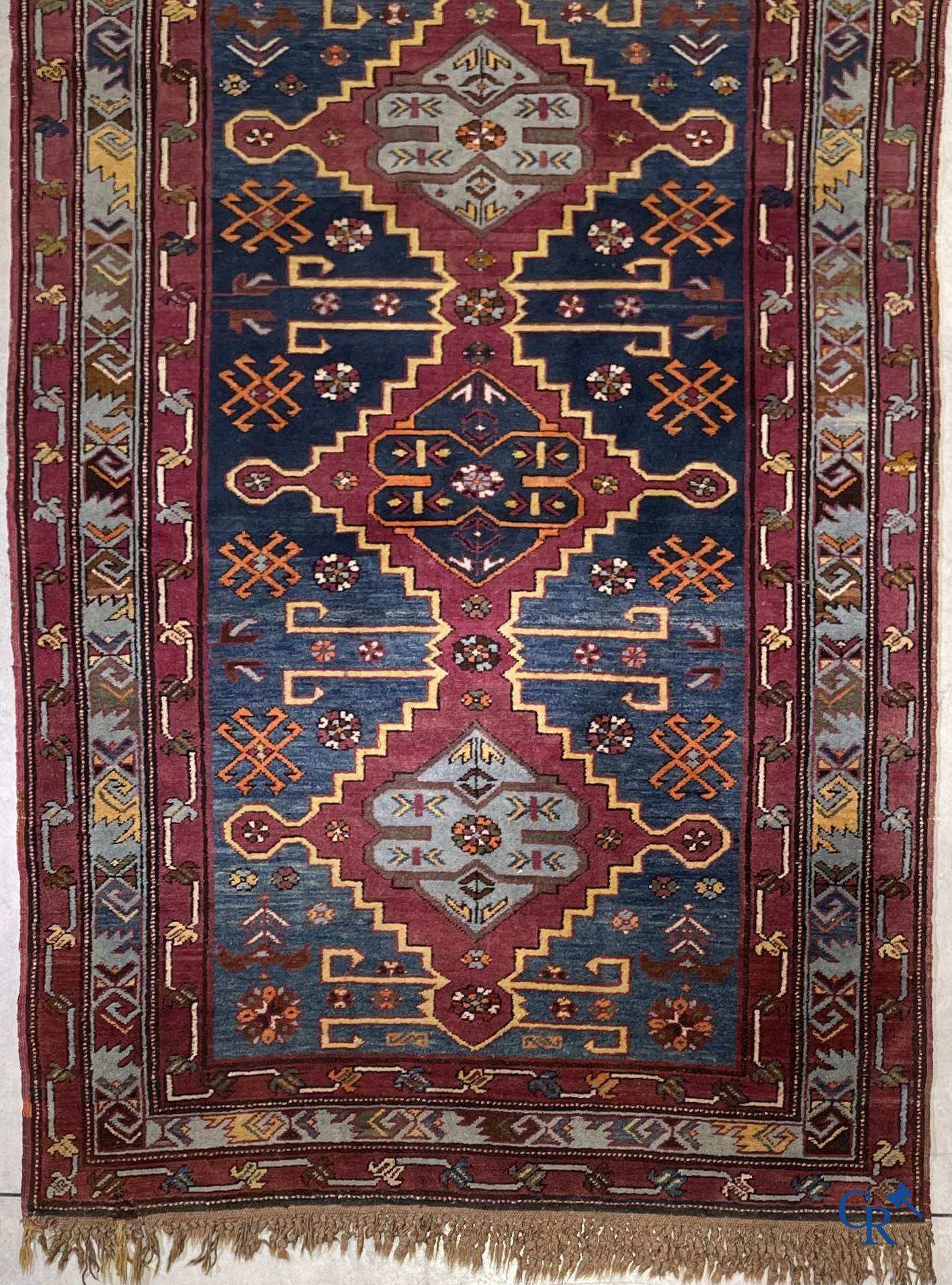 Oriental carpets, an antique hand-knotted Oriental carpet with motifs on a blue background.