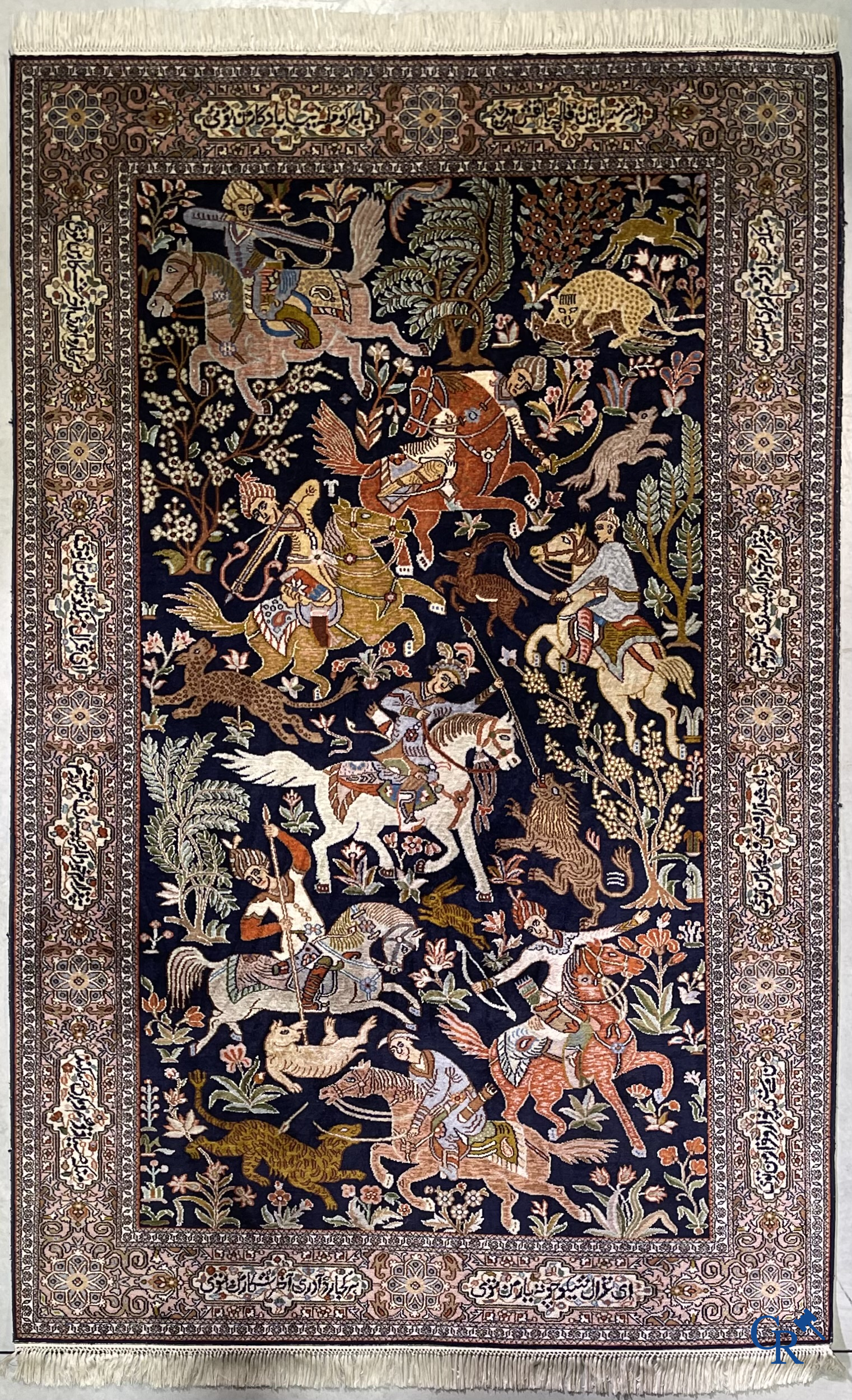 Oriental rugs. Iran. A finely hand-knotted Persian rug in wool and silk with hunters on horseback and inscriptions.