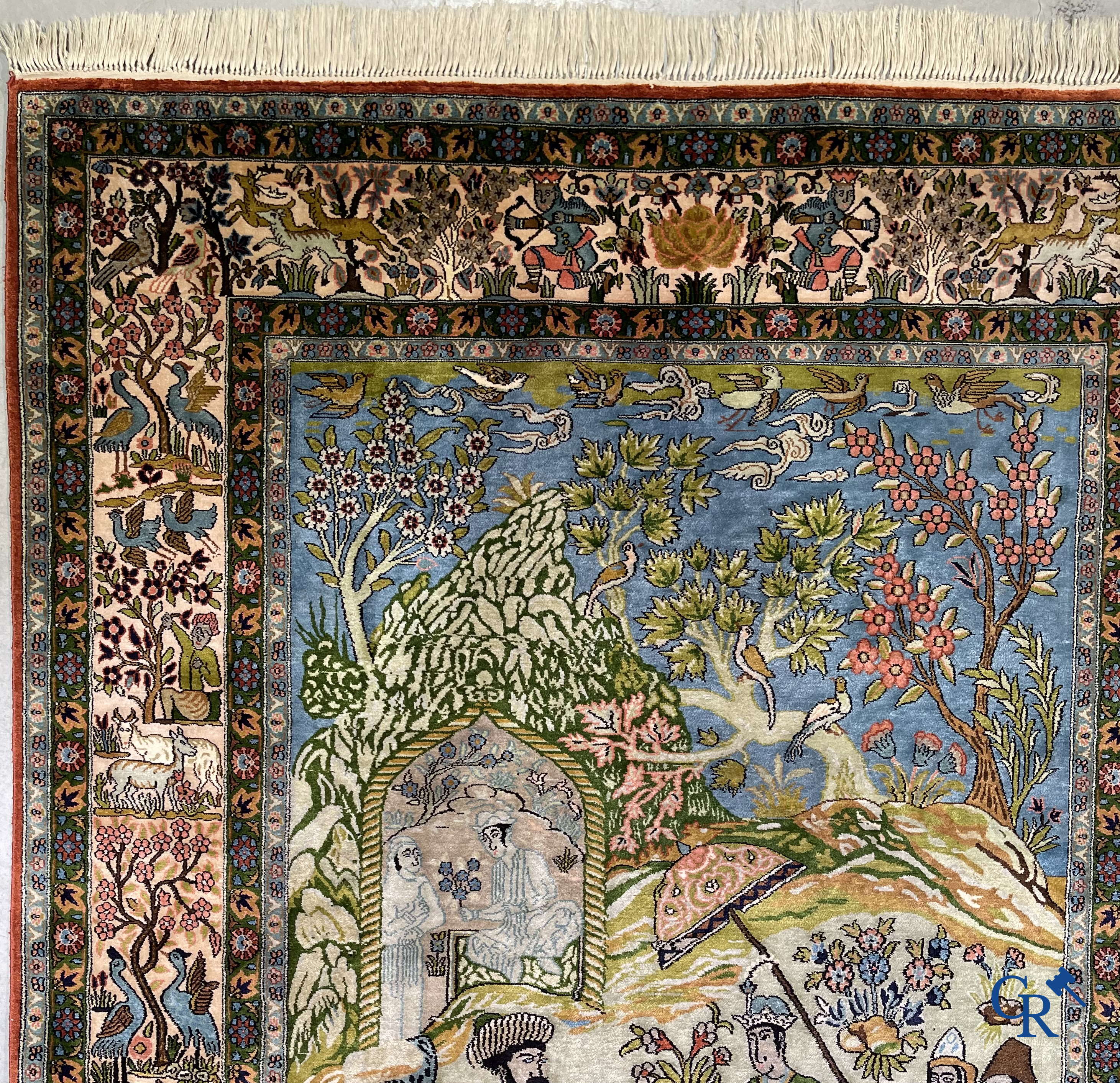 Tapis d'Orient. Iran. Un tapis persan en soie finement noué à la main avec des personnages et un cheval dans un paysage.