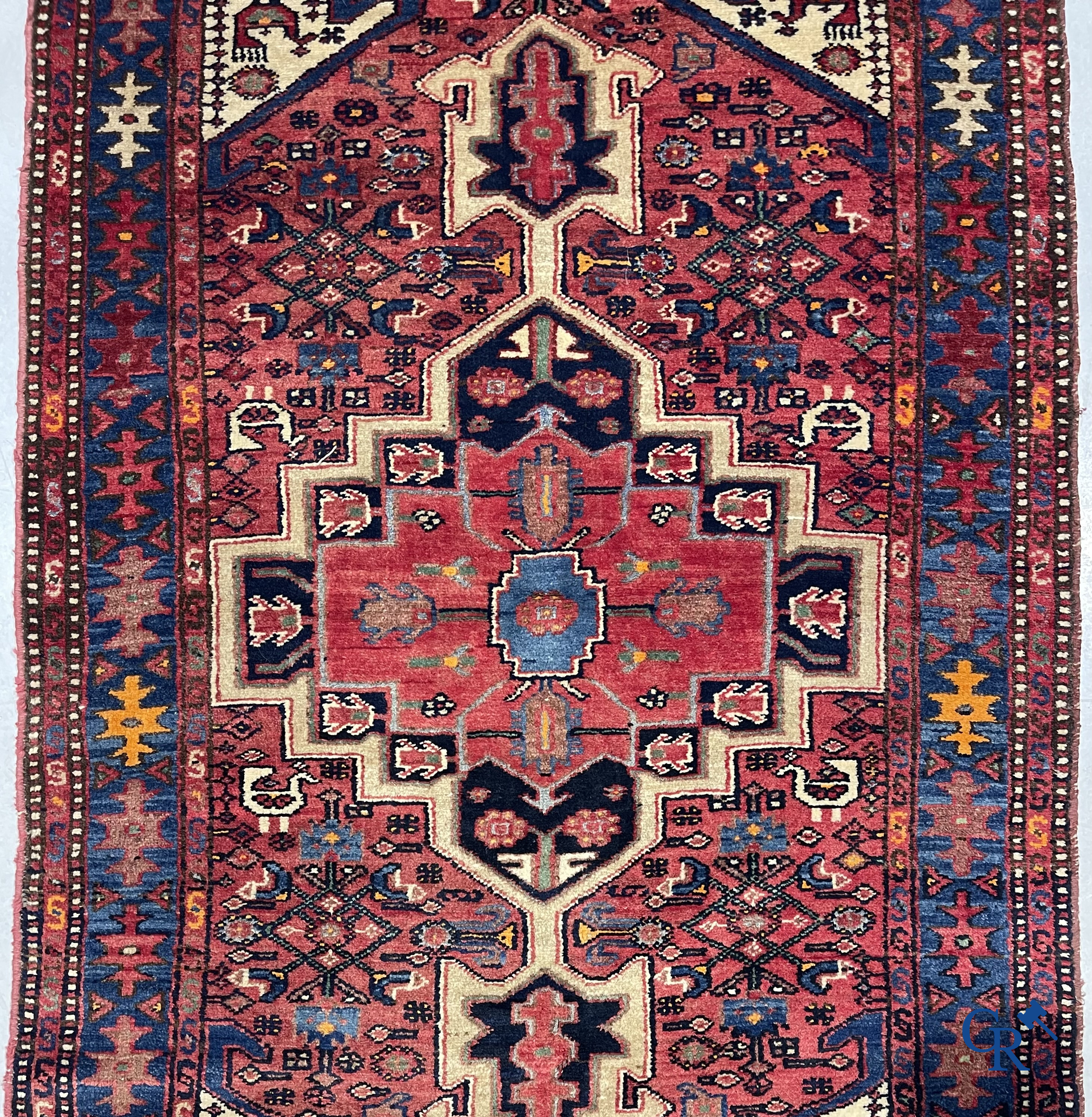 Oriental carpets. Antique hand-knotted Persian carpet with dark red background.