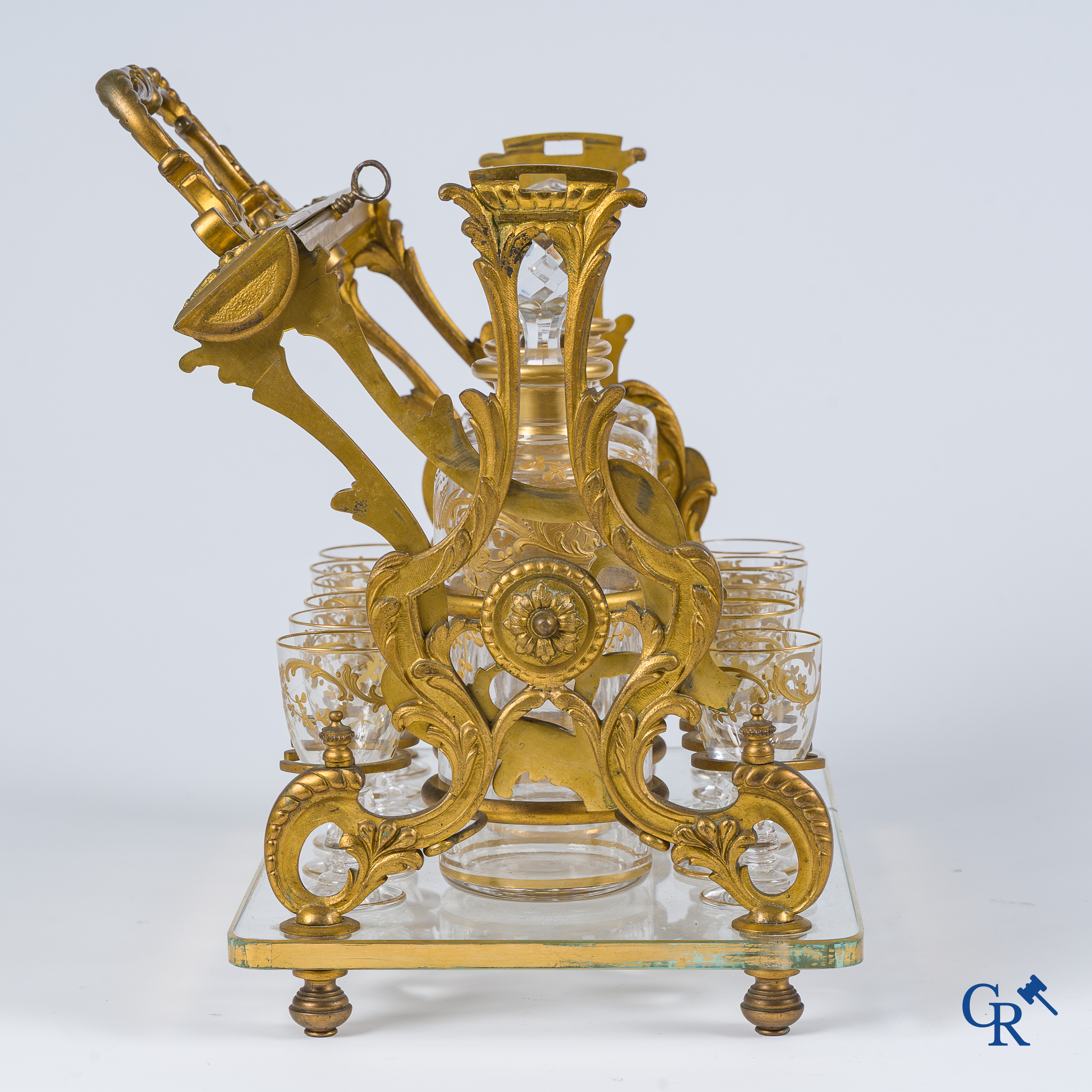 Napoleon III-Periode. Open likeurkelder in vergulde brons met 3 karaffen en 12 glaasjes. Slotmechanisme. Circa 1860.