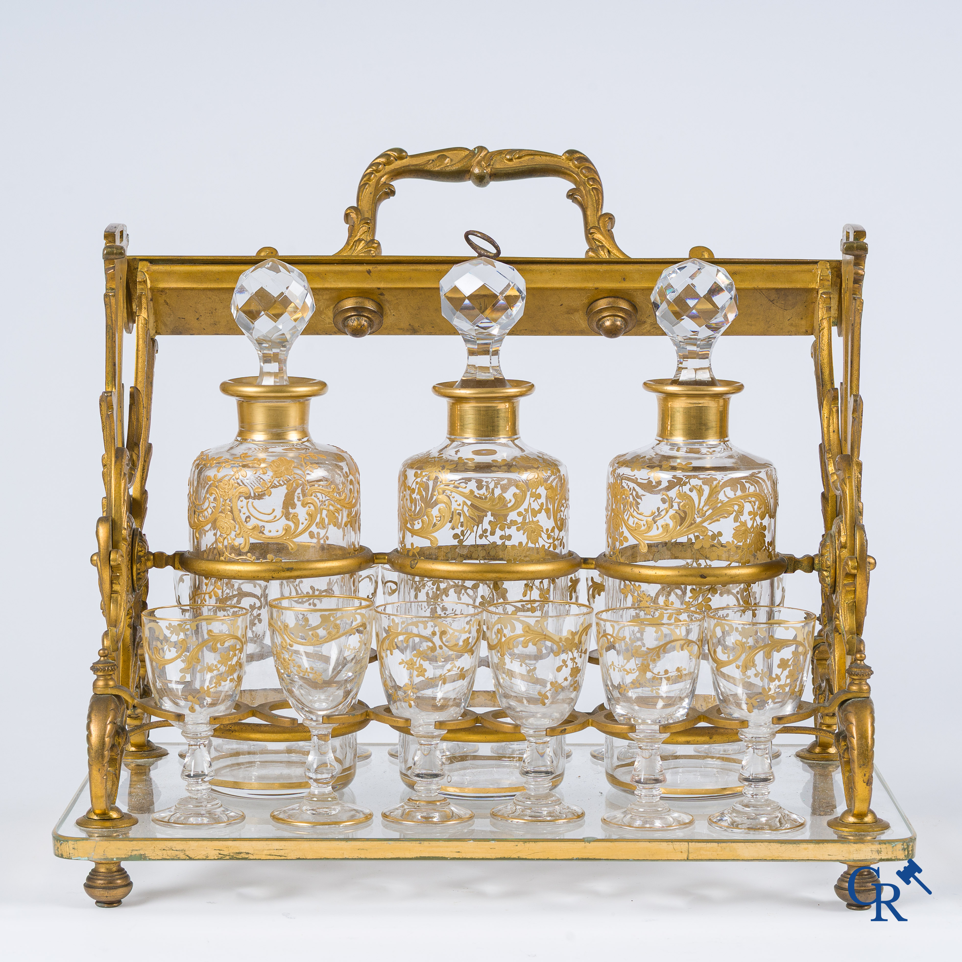 Napoleon III-Periode. Open likeurkelder in vergulde brons met 3 karaffen en 12 glaasjes. Slotmechanisme. Circa 1860.