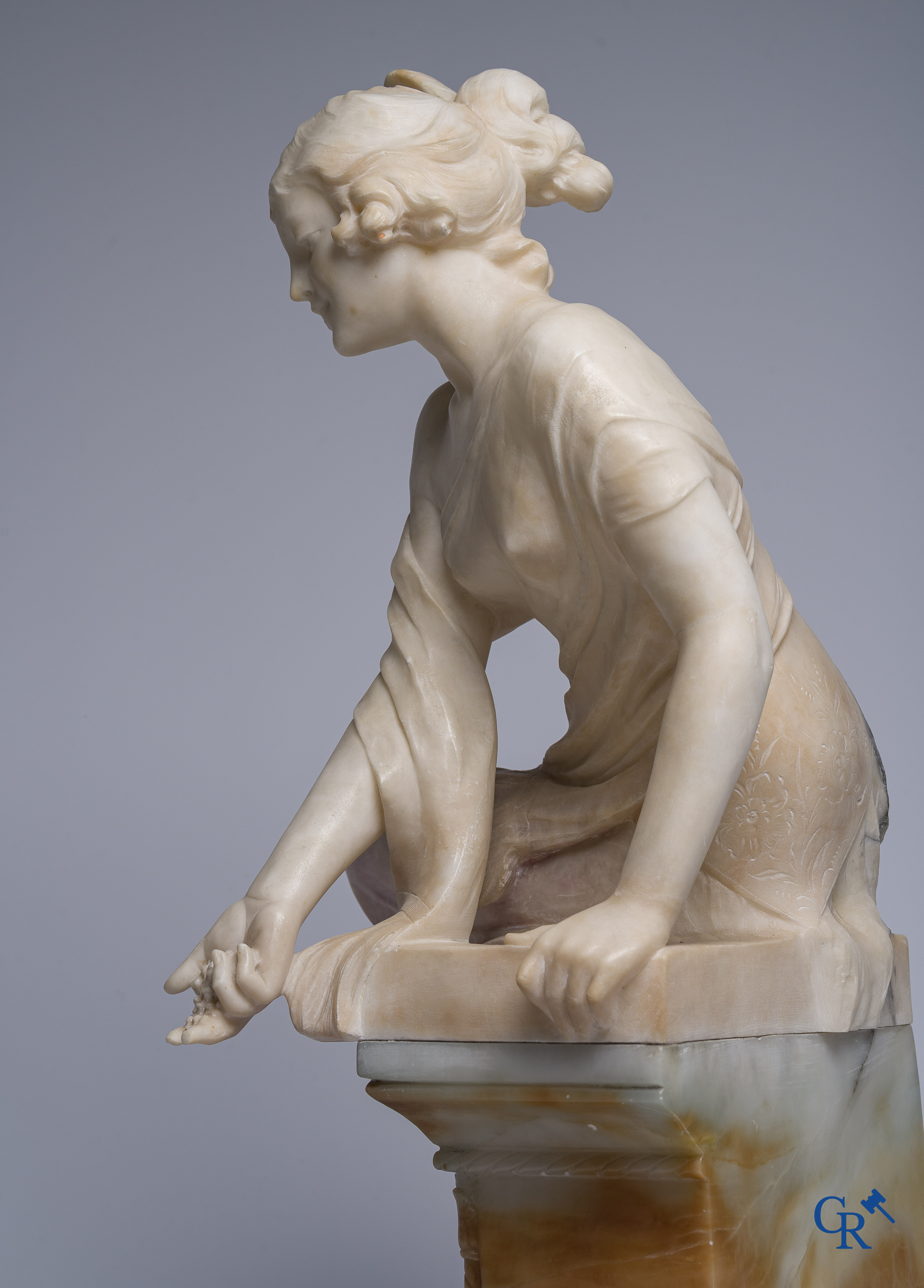 Art Nouveau. Voorstelling van een jongedame gesculpteerd in meerkleurig marmer met bronzen vogels. Circa 1910.