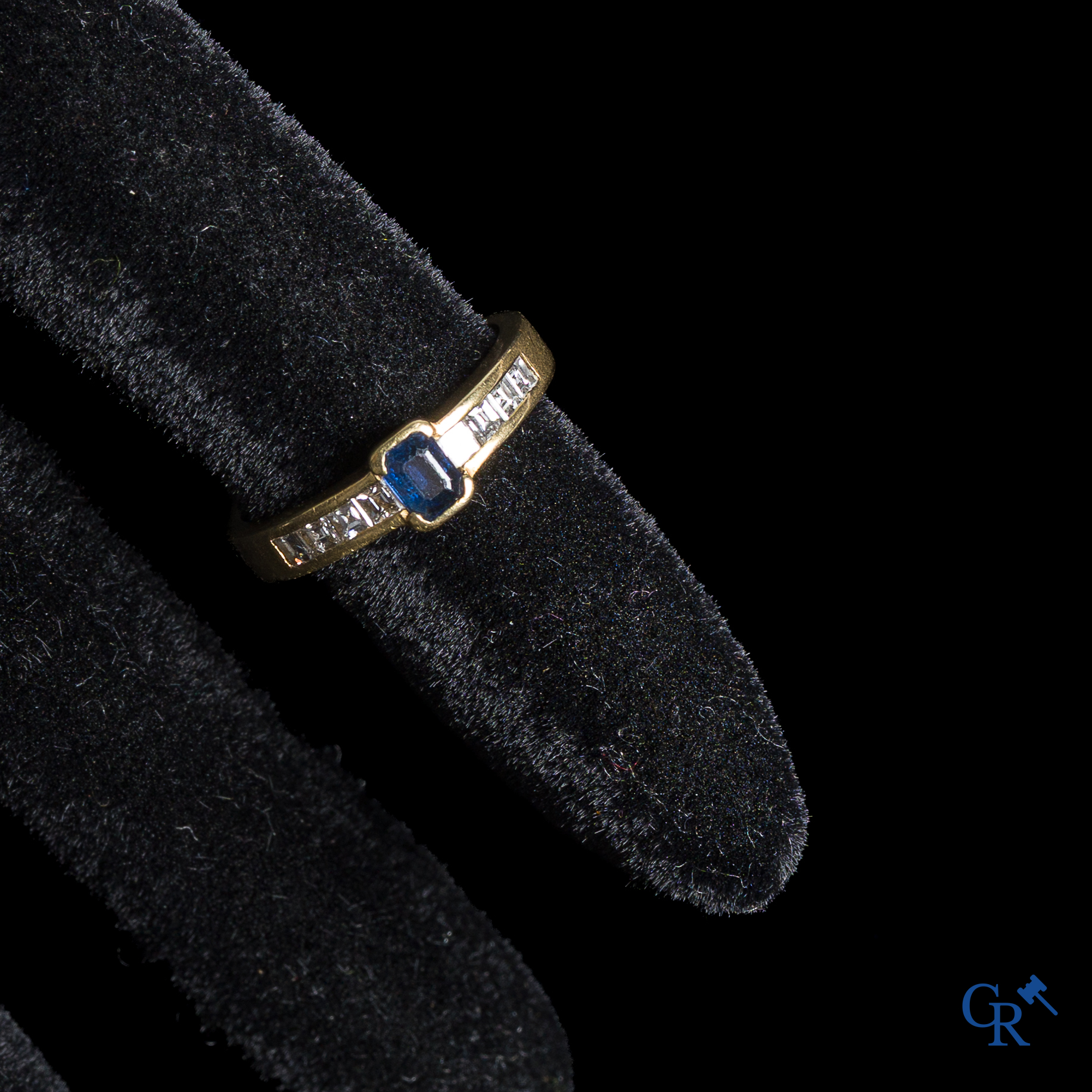 Juwelen. Ring in goud 750°/00 met een blauwe saffier en diamanten.
