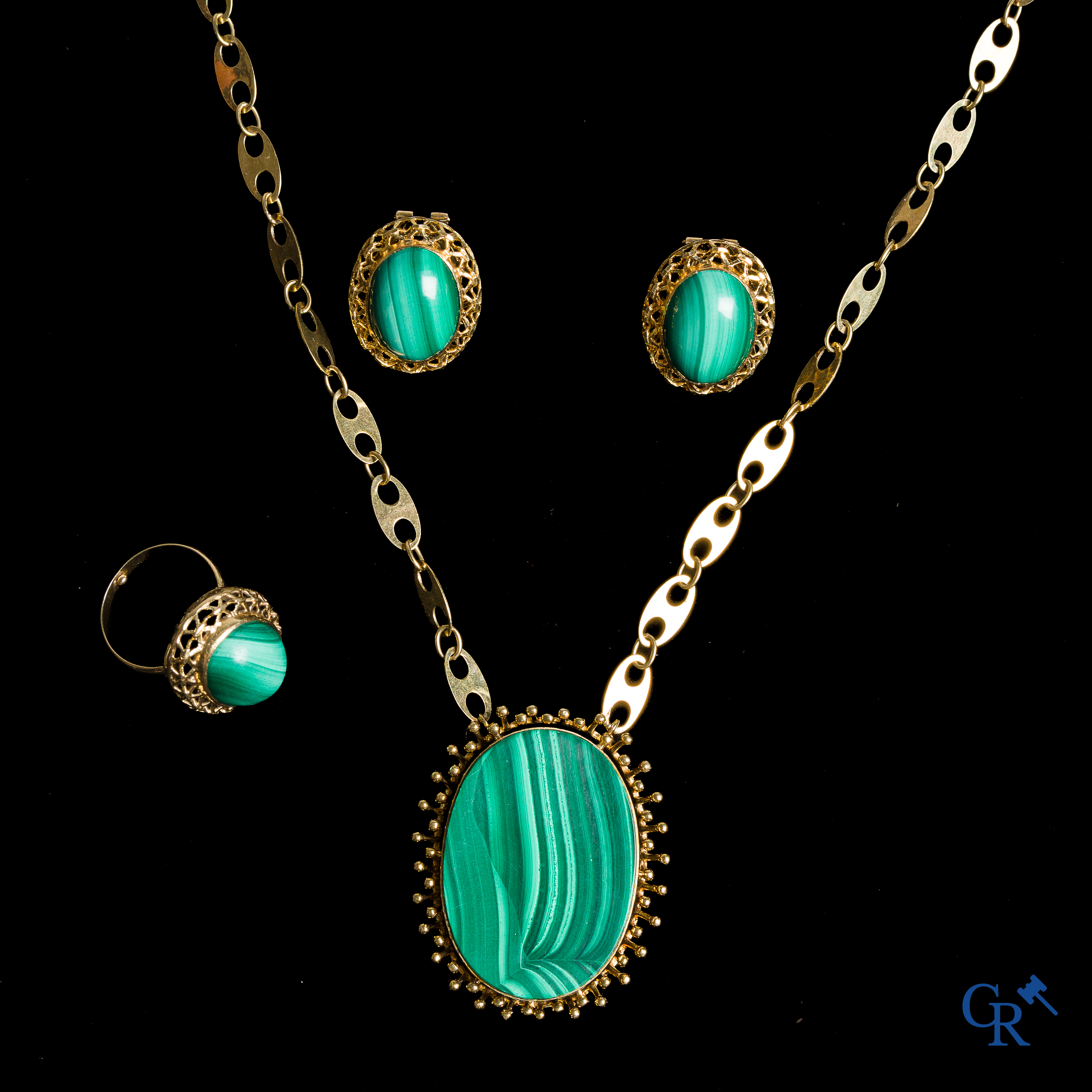 Parure en or 750°/00 sertie de malachite, composée d'un collier avec pendentif, d'une paire de boucles d'oreilles et d'une bague.