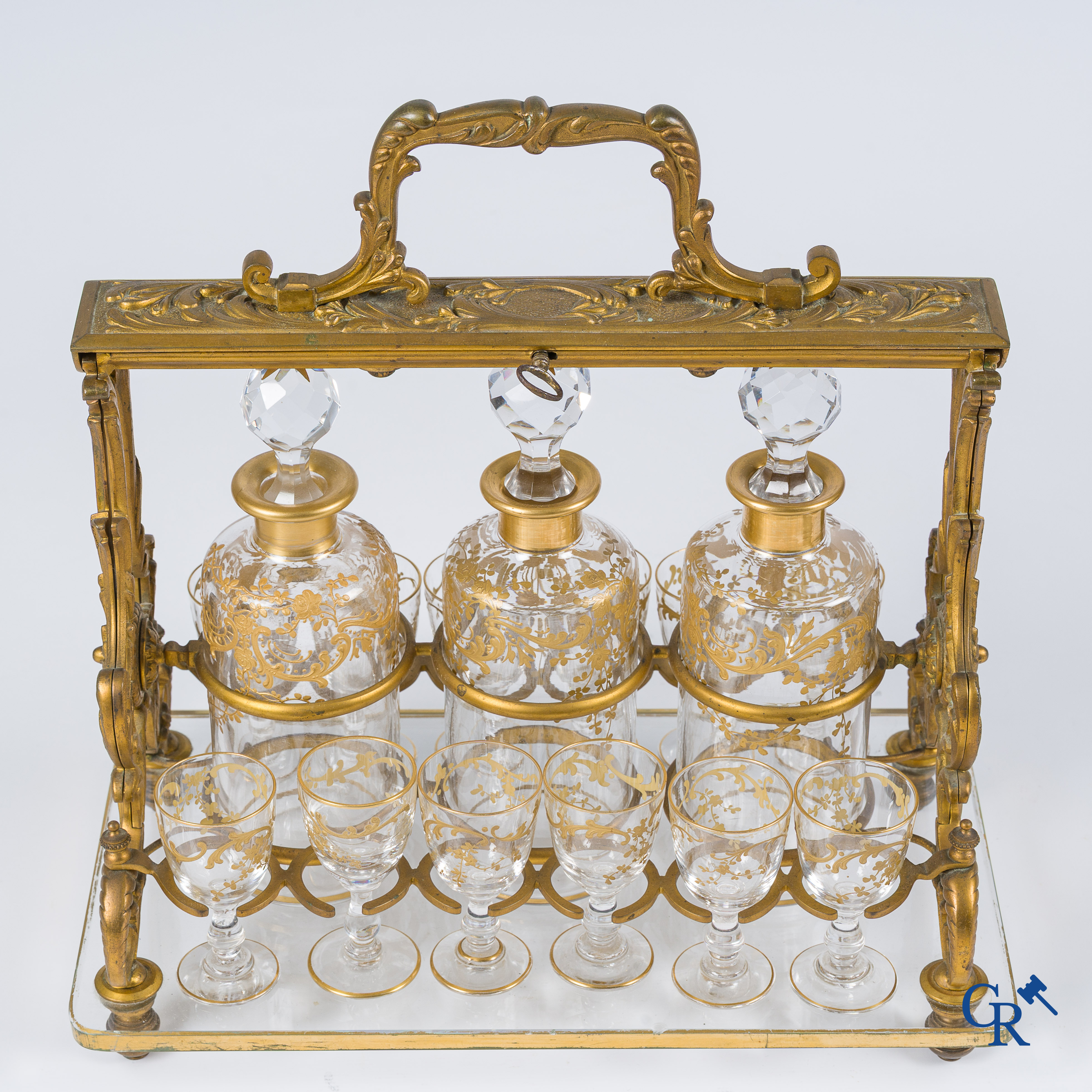 Napoleon III-Periode. Open likeurkelder in vergulde brons met 3 karaffen en 12 glaasjes. Slotmechanisme. Circa 1860.
