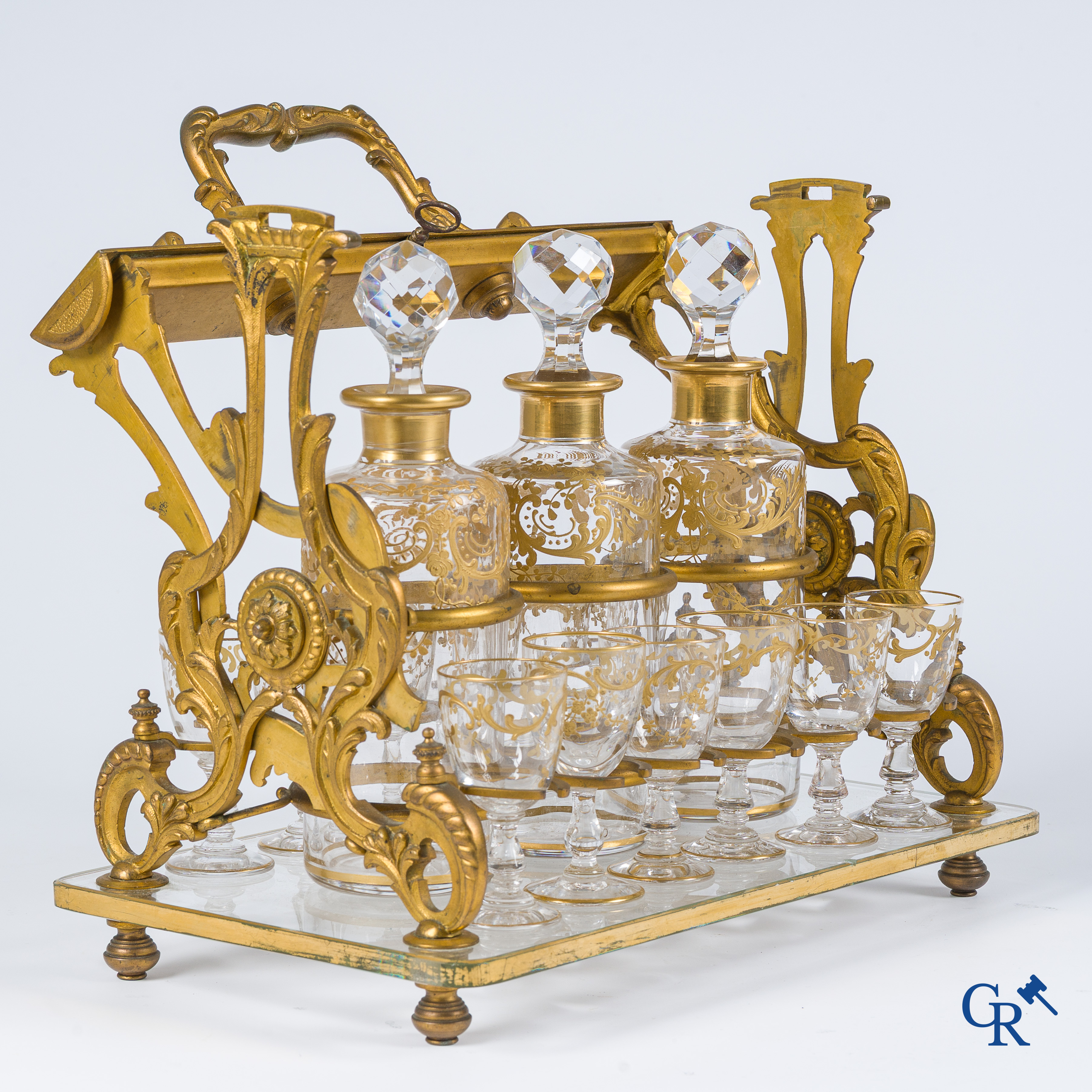 Napoleon III-Periode. Open likeurkelder in vergulde brons met 3 karaffen en 12 glaasjes. Slotmechanisme. Circa 1860.