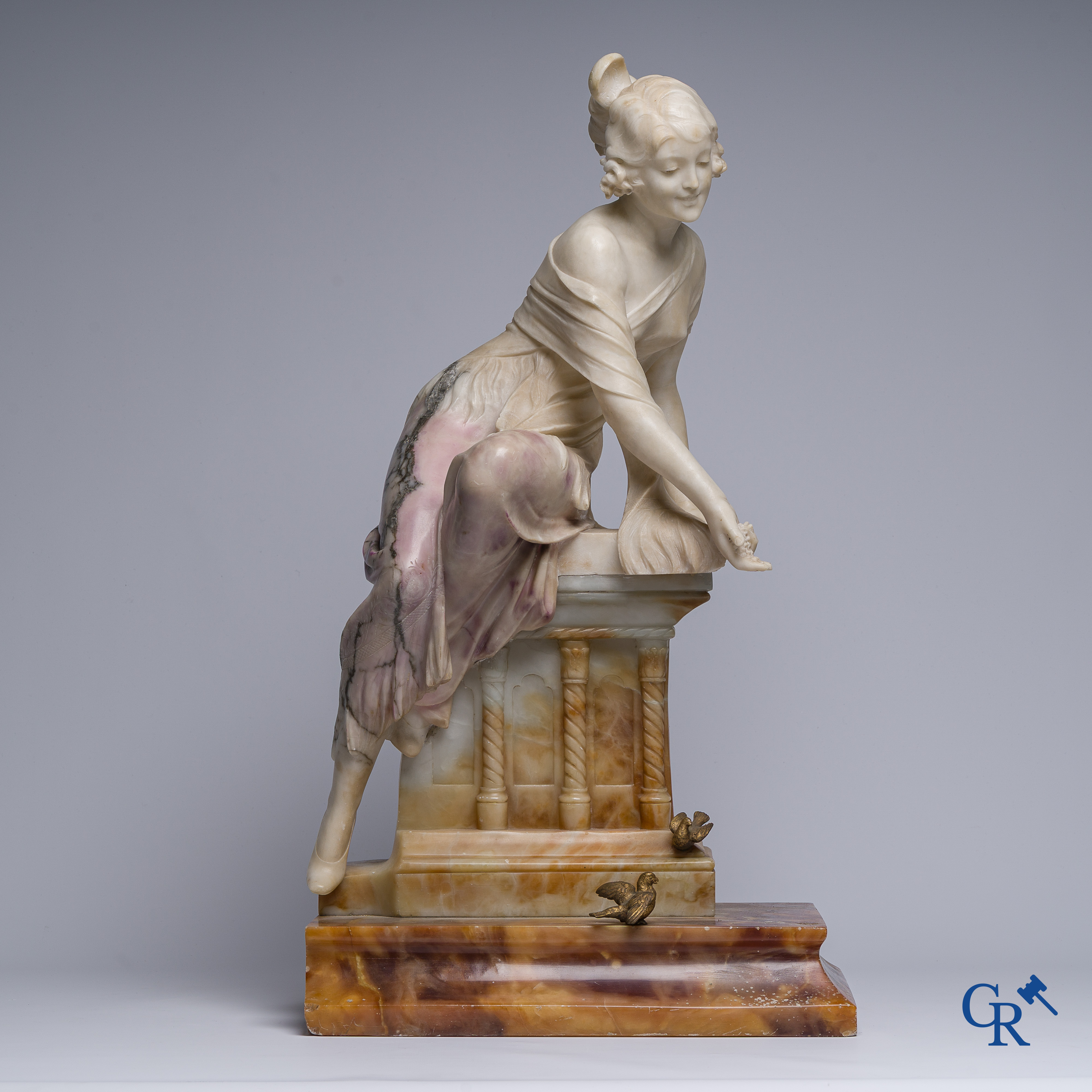 Art Nouveau. Voorstelling van een jongedame gesculpteerd in meerkleurig marmer met bronzen vogels. Circa 1910.