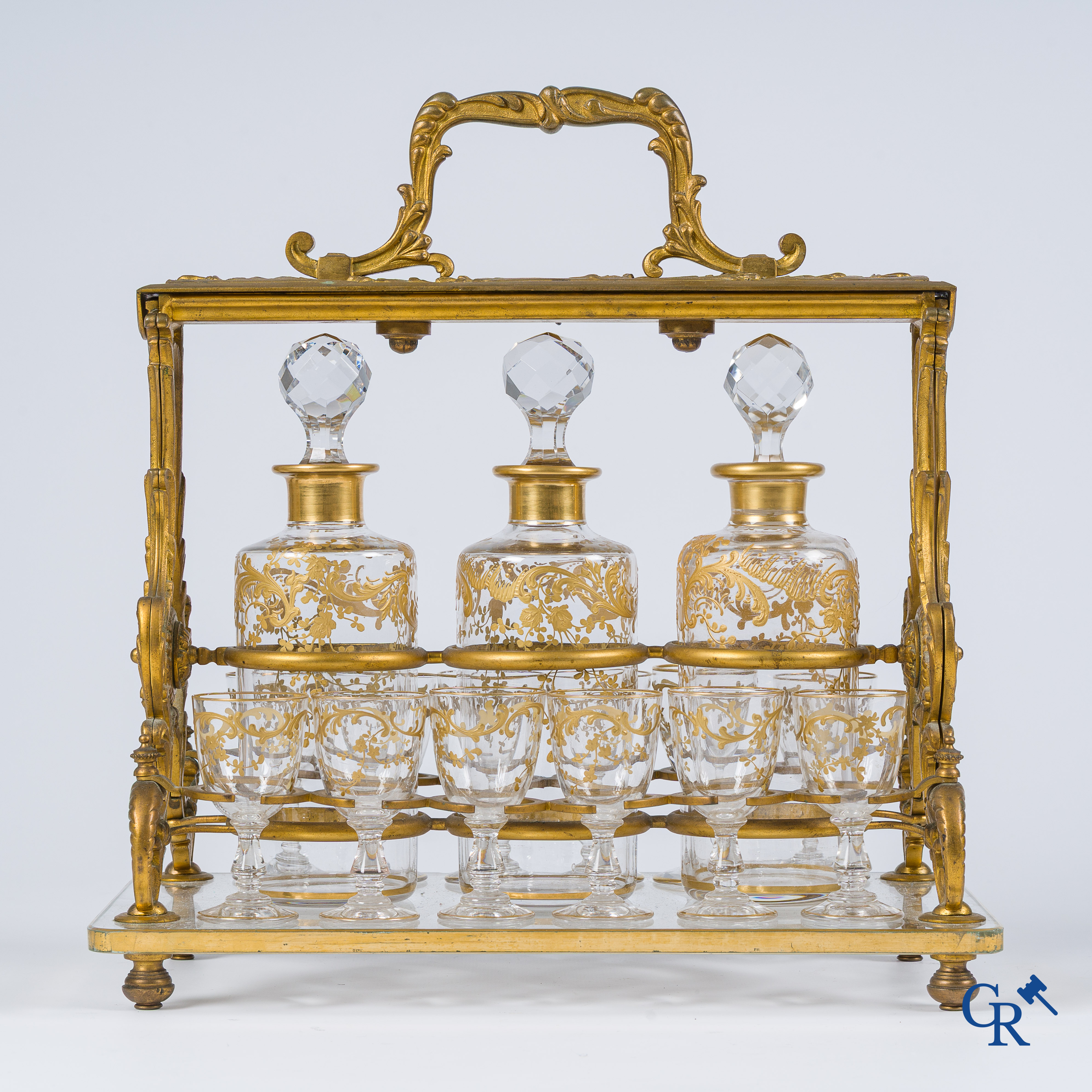 Napoleon III-Periode. Open likeurkelder in vergulde brons met 3 karaffen en 12 glaasjes. Slotmechanisme. Circa 1860.
