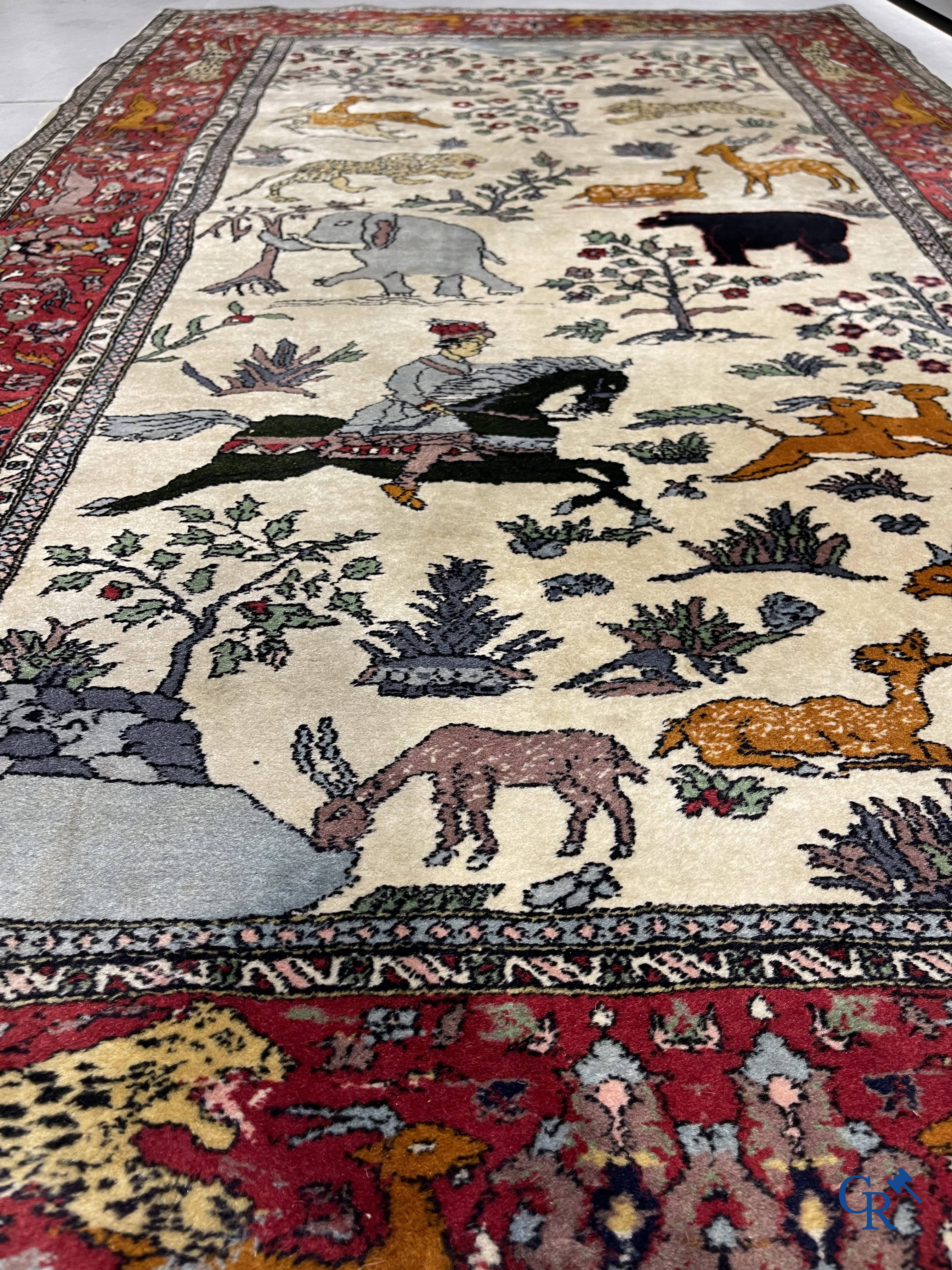 Oosterse tapijten. Handgeknoopt tapijt met taferelen van dieren in een landschap.