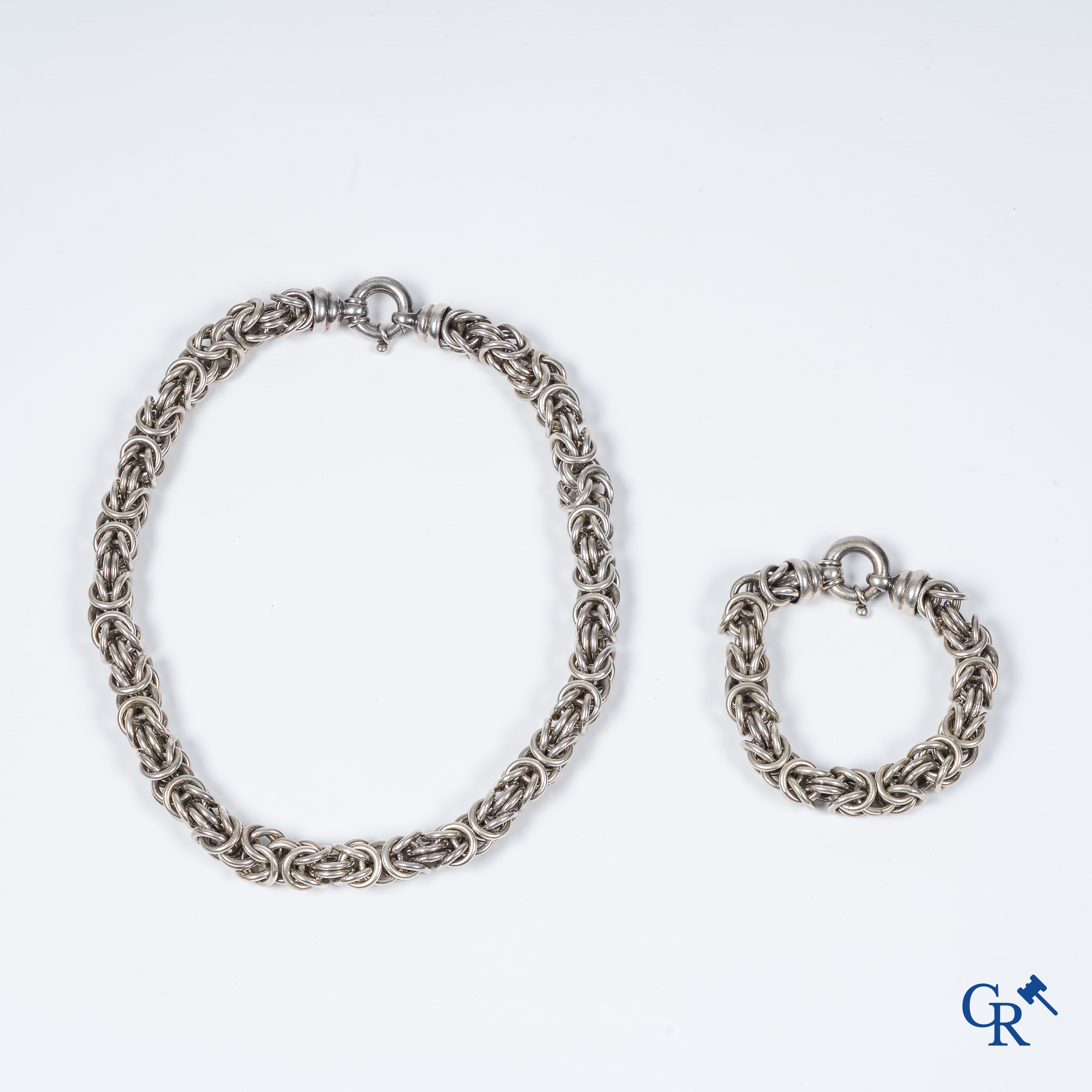 Juwelen. Een halsketting en armband in zilver.