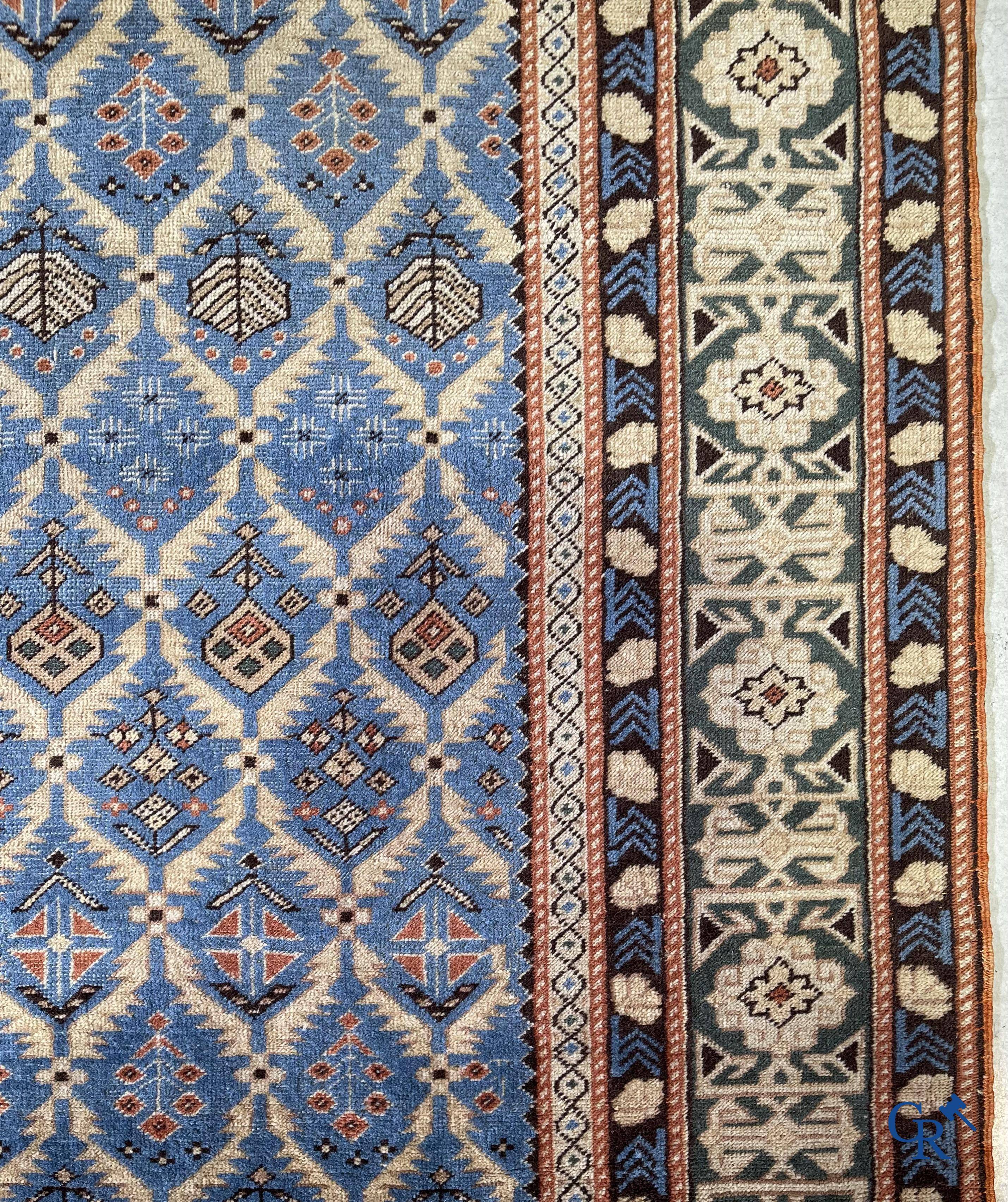 Antique Oriental carpets, an antique Dagestan carpet with motifs on a blue background.