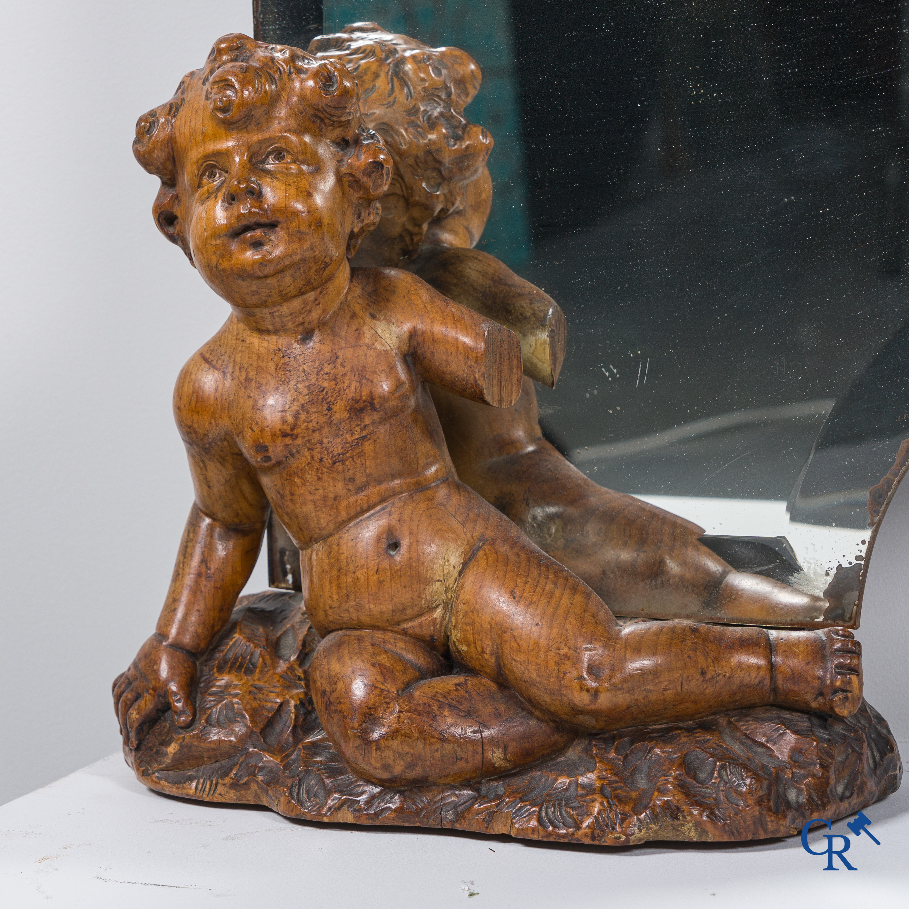 Un grand miroir entouré de 6 putti en bois sculpté. Vers 1900.