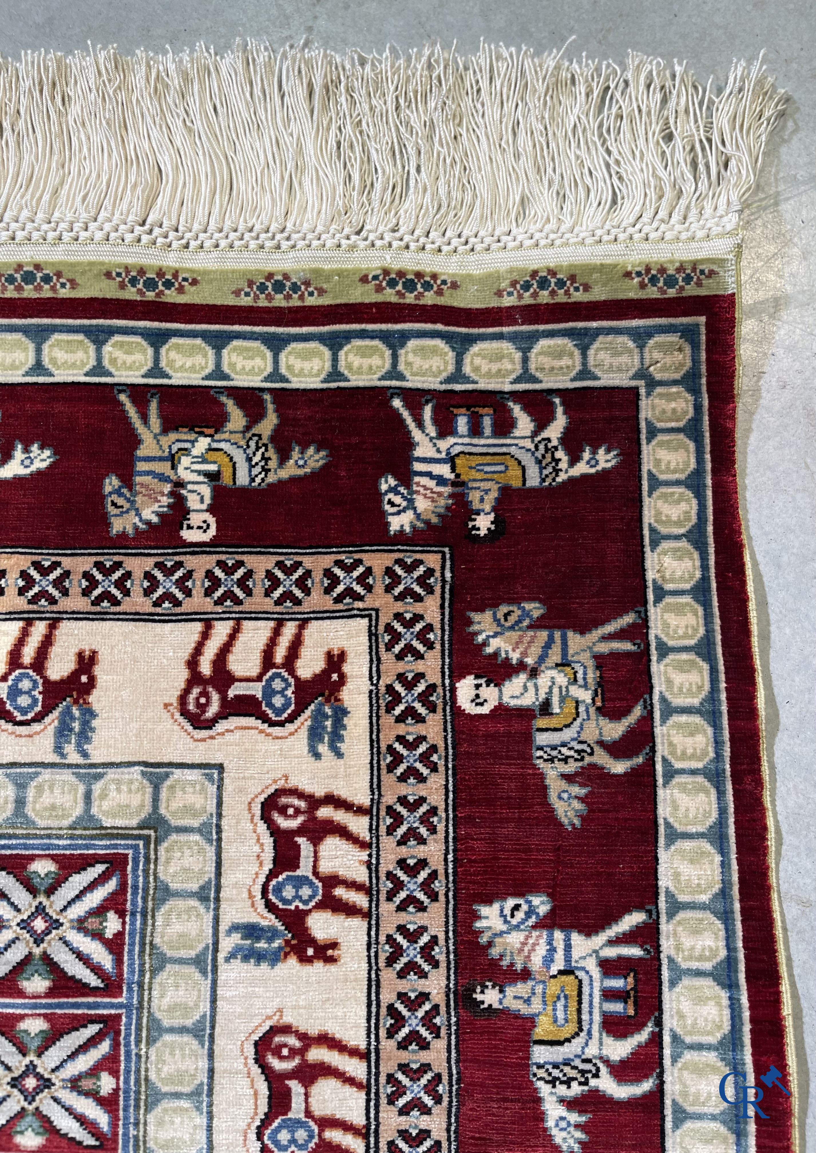 Oriental rugs: A small finely hand-knotted silk rug with deer and horsemen. Signed.