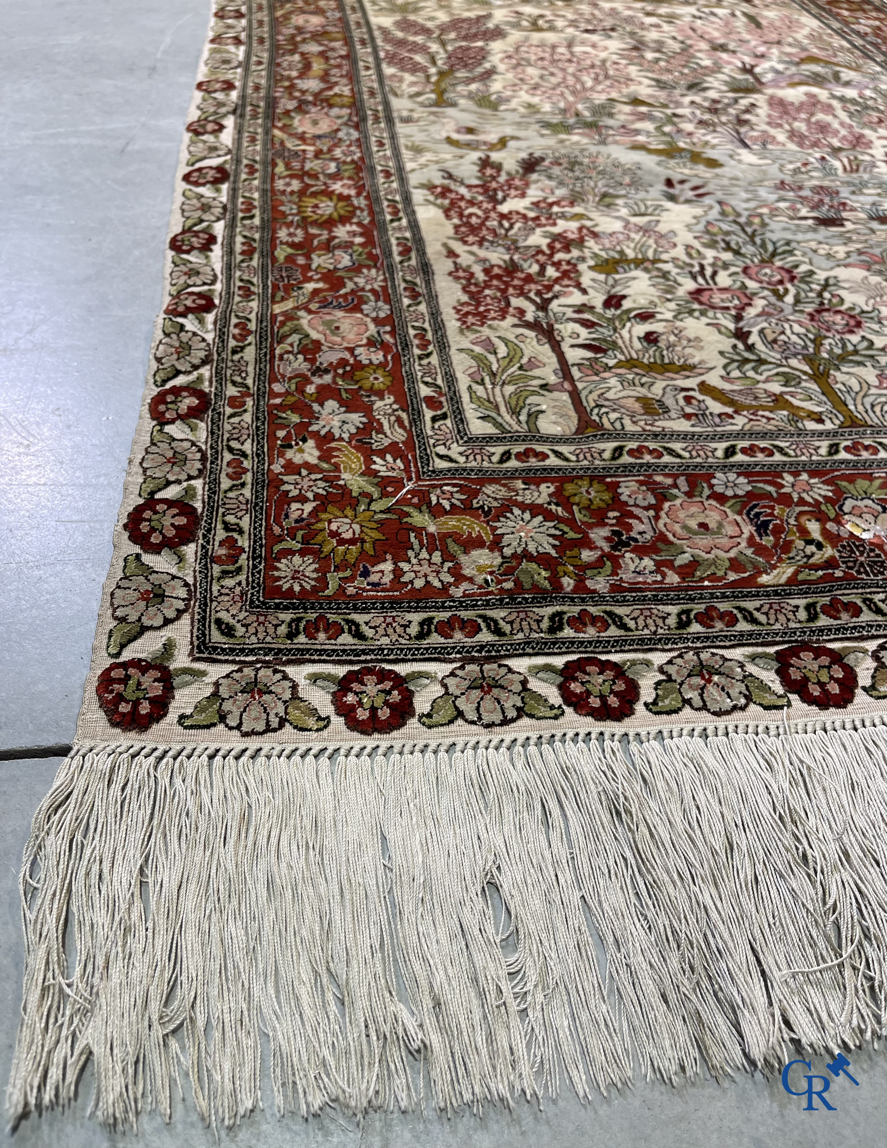 Oriental carpets: A finely hand-knotted silk carpet with water birds in a landscape on a floral background.