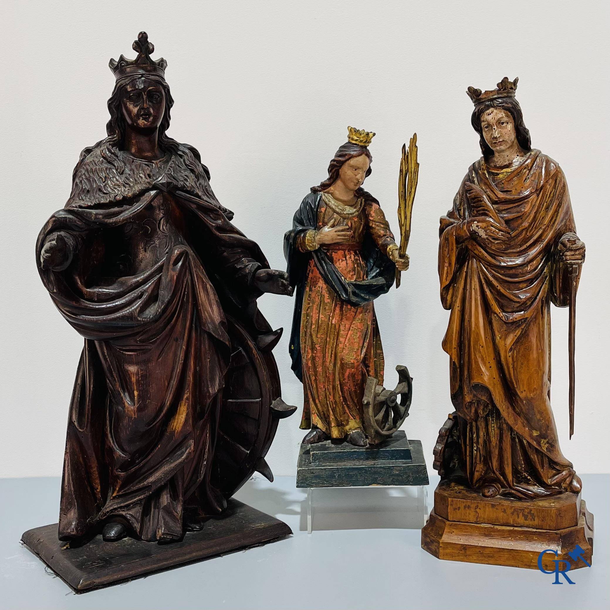 Religieuze objecten, 3 antieke hout gesculpteerde voorstellingen van St. Catharina. 18e-19e eeuw.