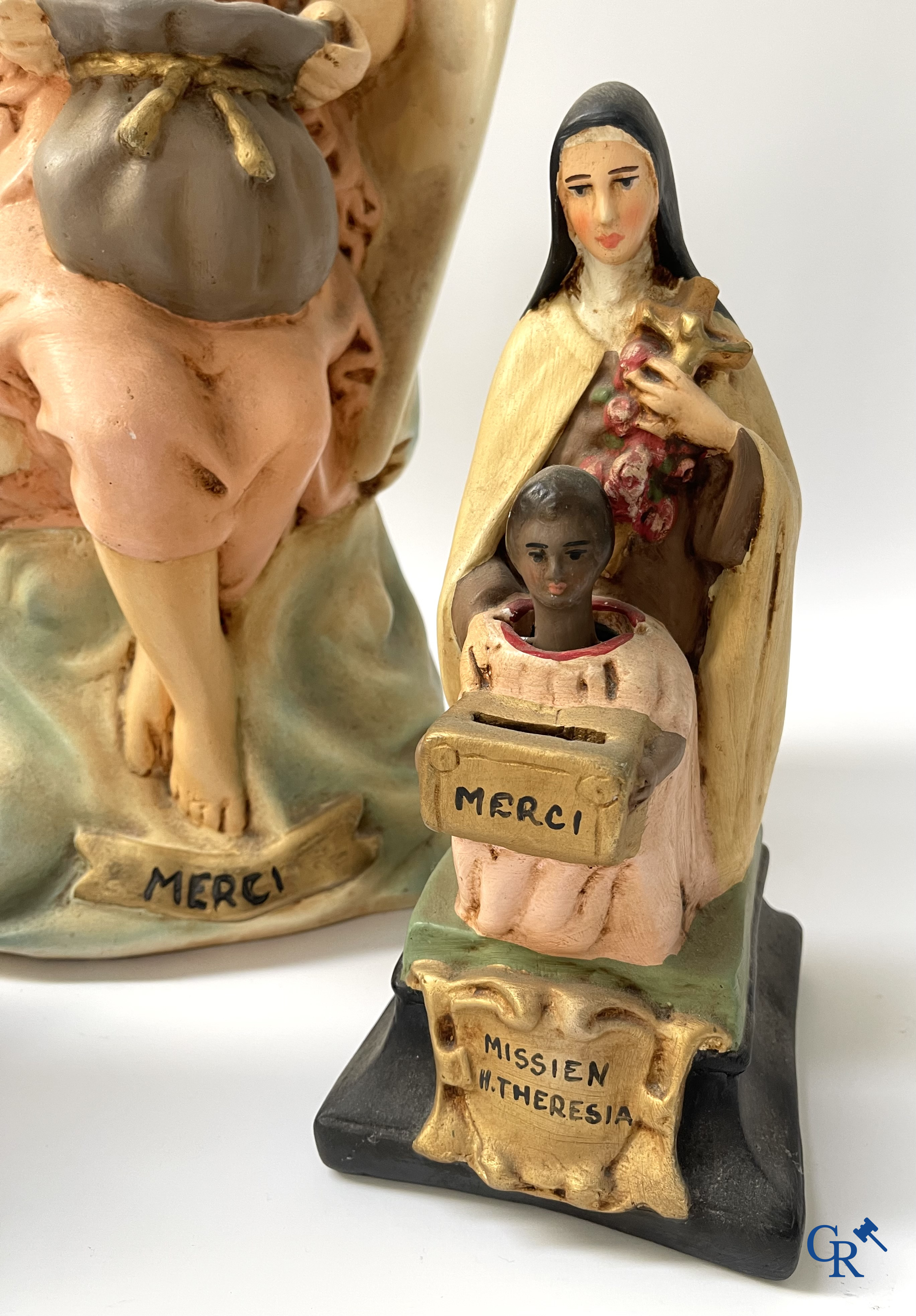 3 tirelires en plâtre avec des têtes qui hochent la tête au profit des Saintes Missions.