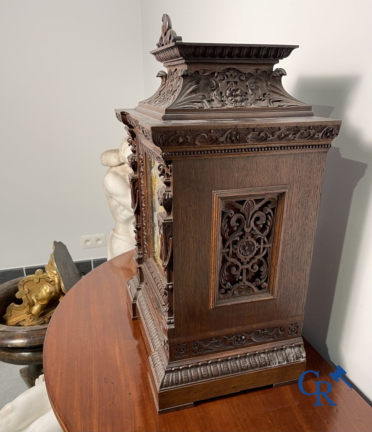 Clock with multiple bells and music in oak sculpted case with matching pedestal.