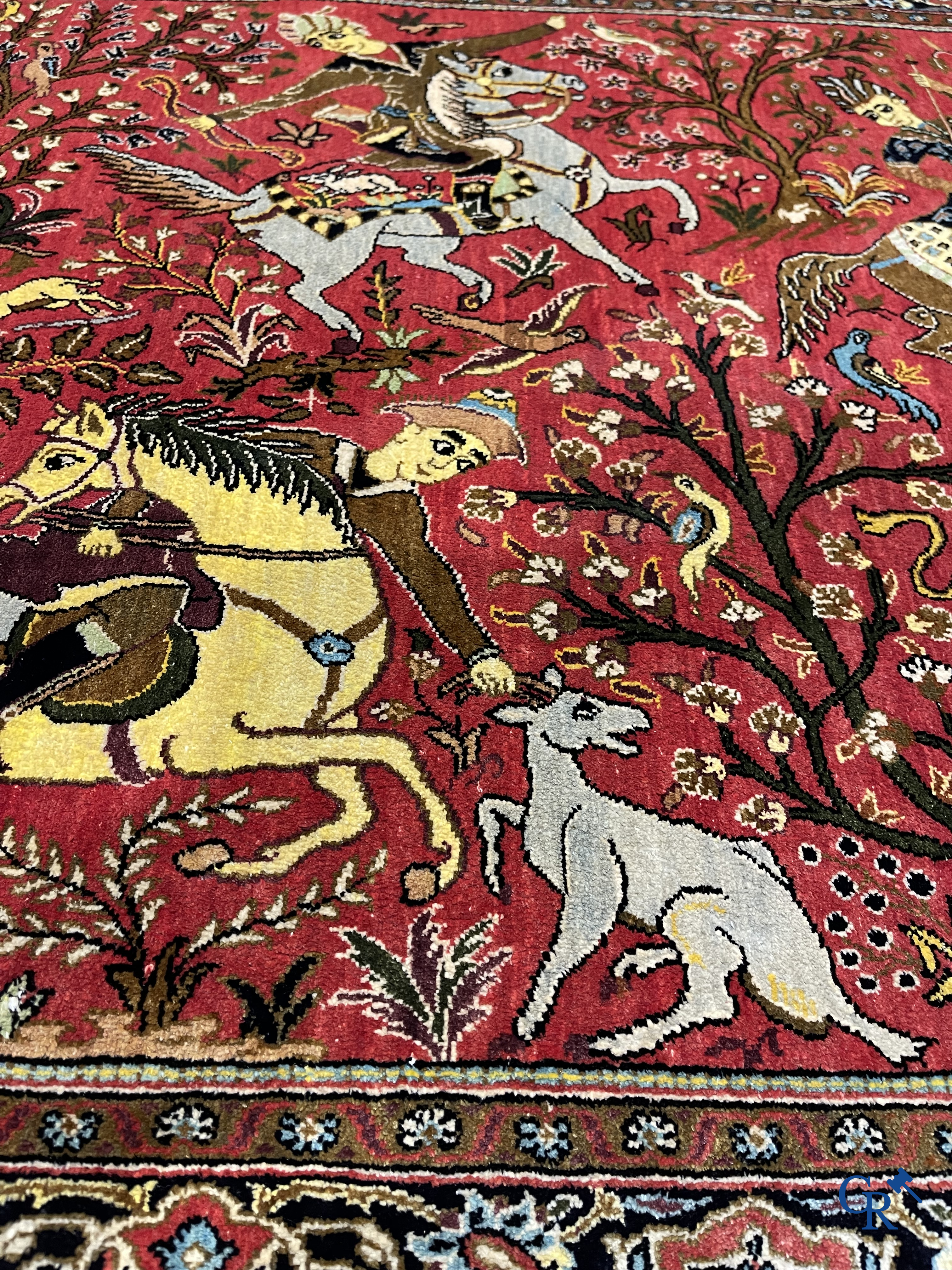 Oriental carpets, a Persian carpet in silk with a scene of hunters on horseback.