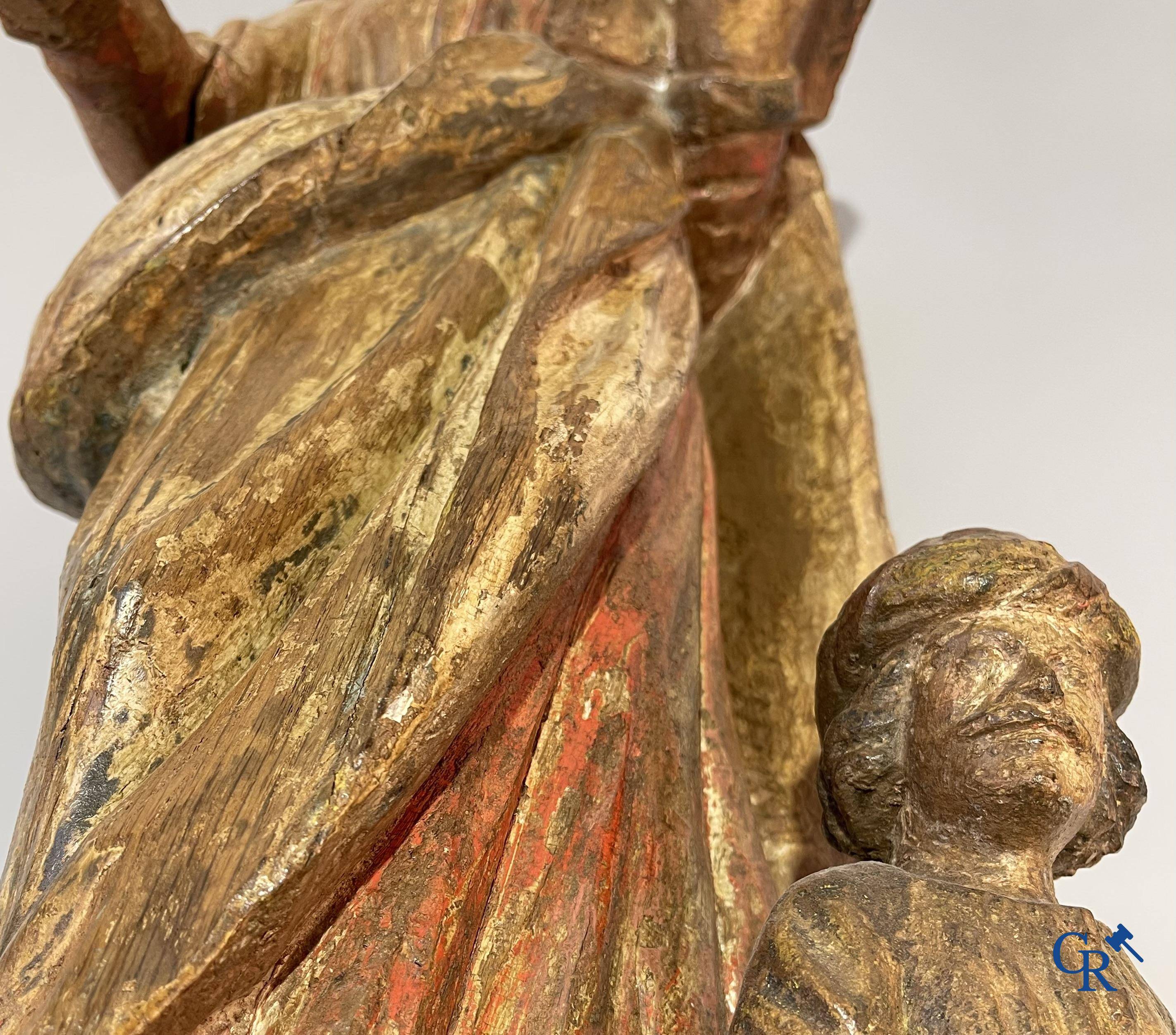 Religieuze objecten: Een houtgesculpteerde voorstelling van Sint Catharina en keizer Maxentius. 17e-18e eeuw.