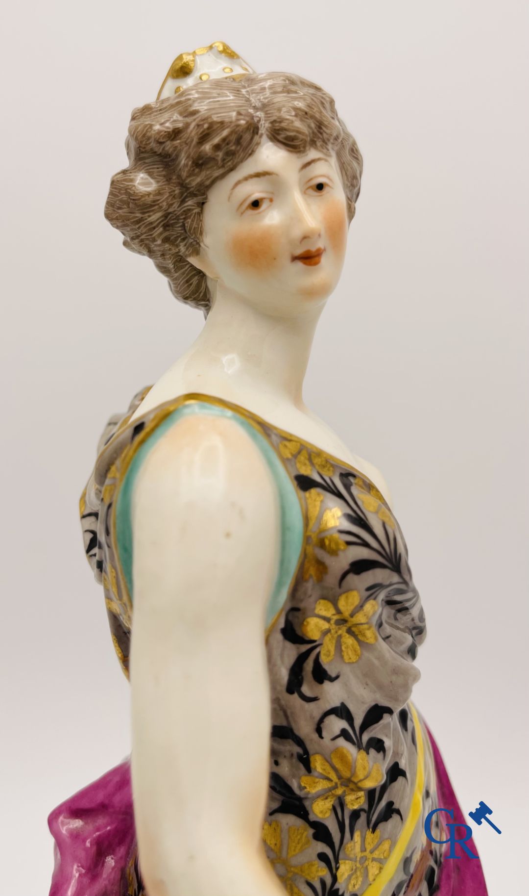 A pair of polychrome porcelain figures in the manner of Meissen.