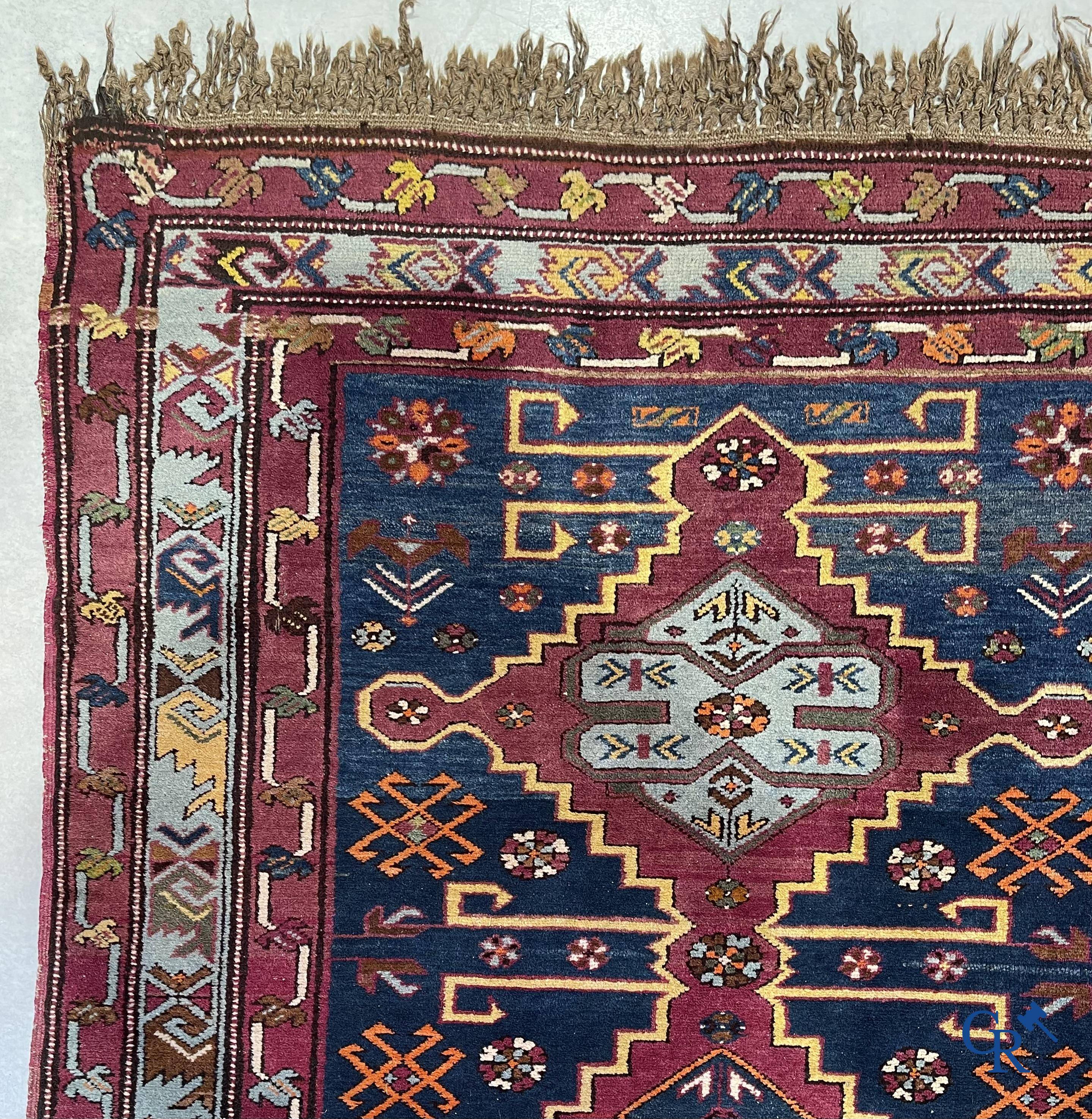 Oriental carpets, an antique hand-knotted Oriental carpet with motifs on a blue background.