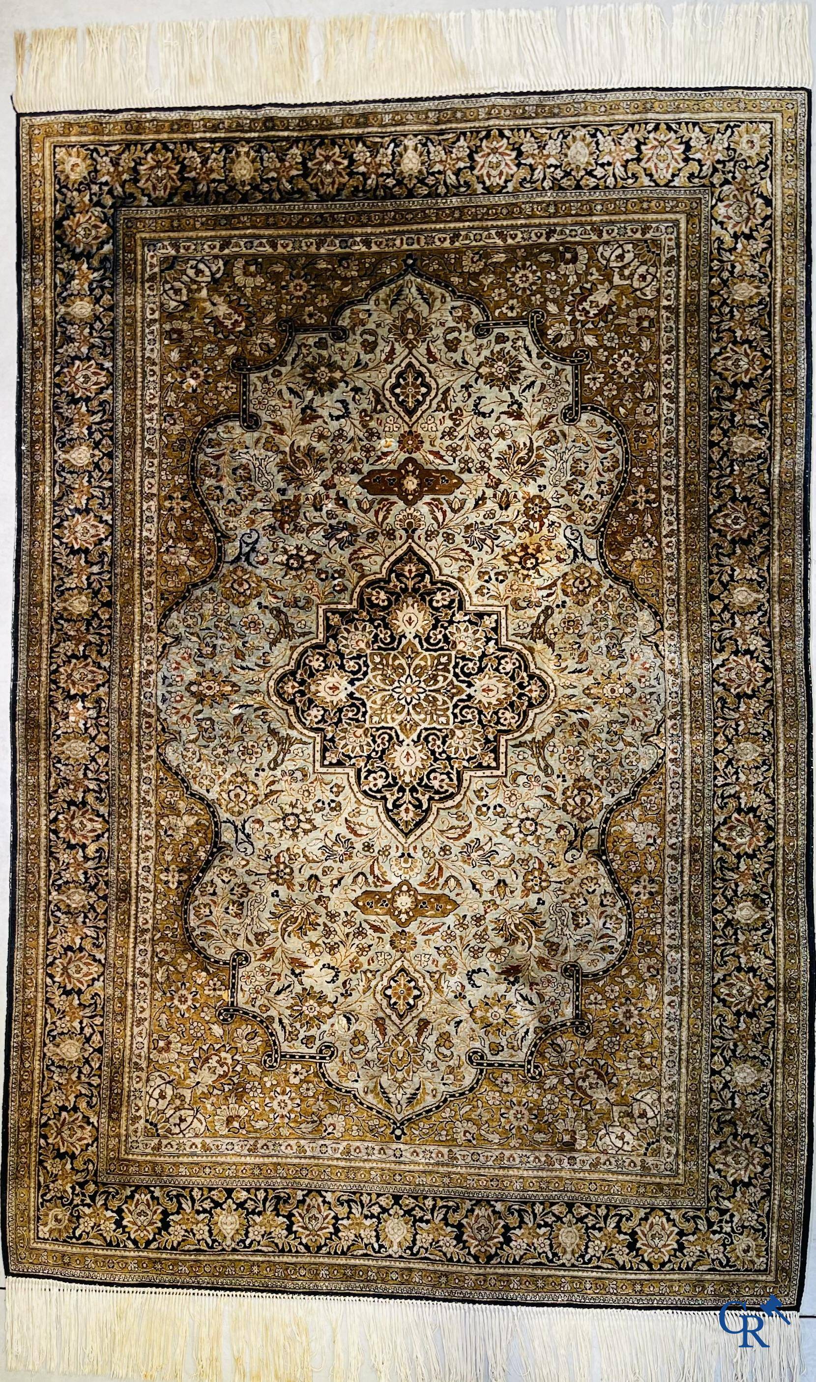 Tapis d'Orient. Un tapis en soie finement noué à la main avec un décor floral.