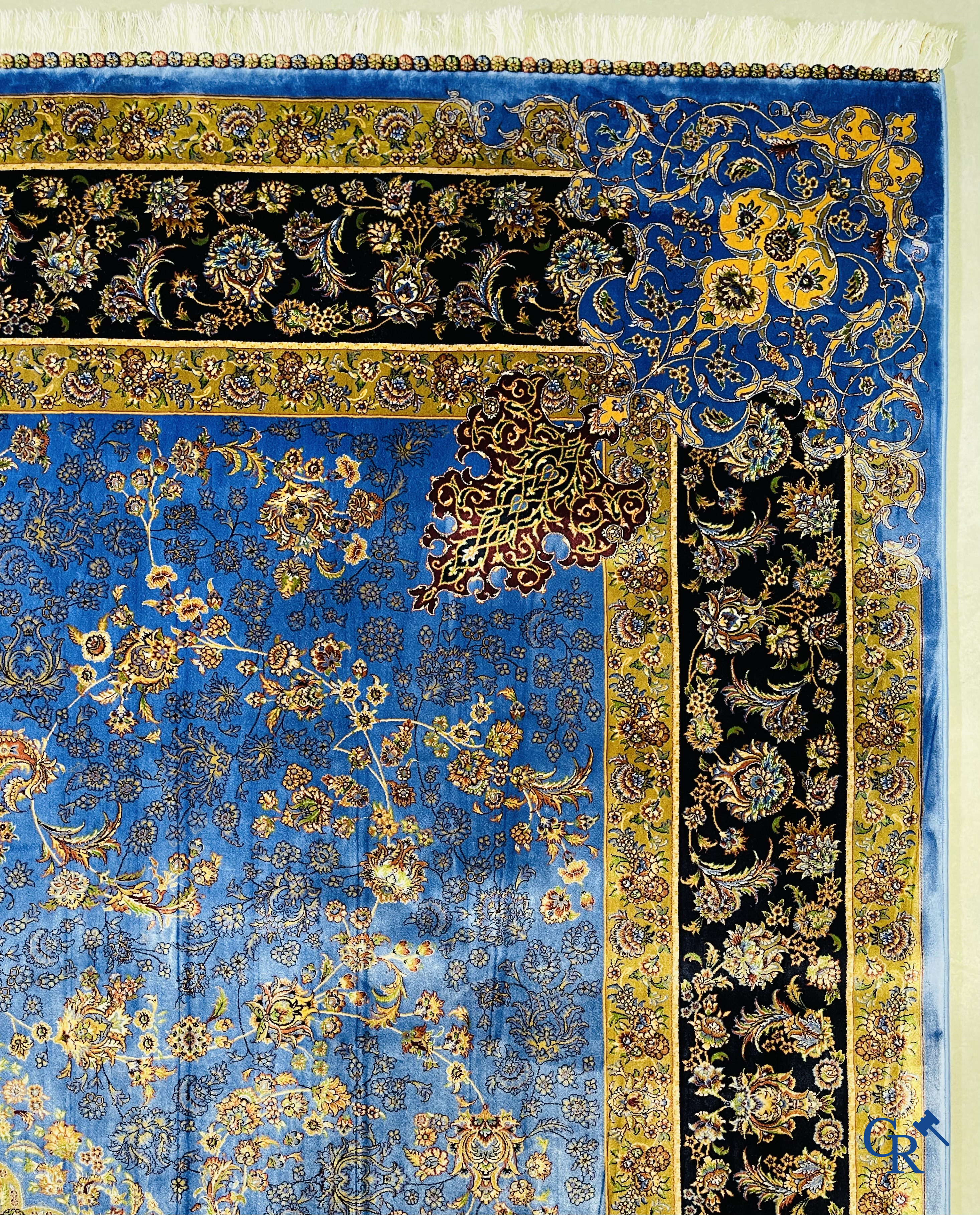 Tapis. Exceptionnel tapis en soie avec un décor floral sur fond bleu.