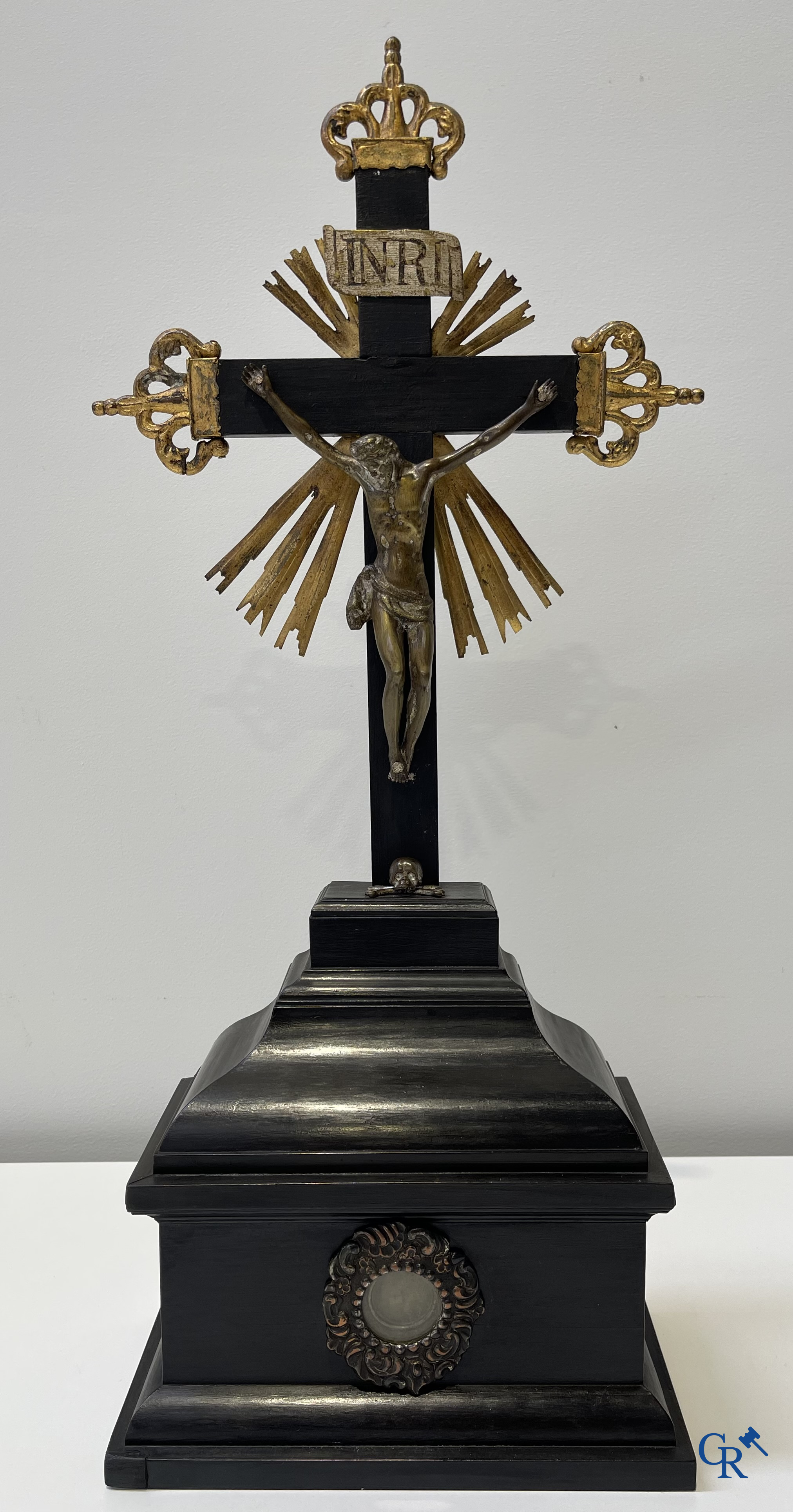 Religious objects: Bronze Christ on the cross held up by an ebony reliquary with relic.