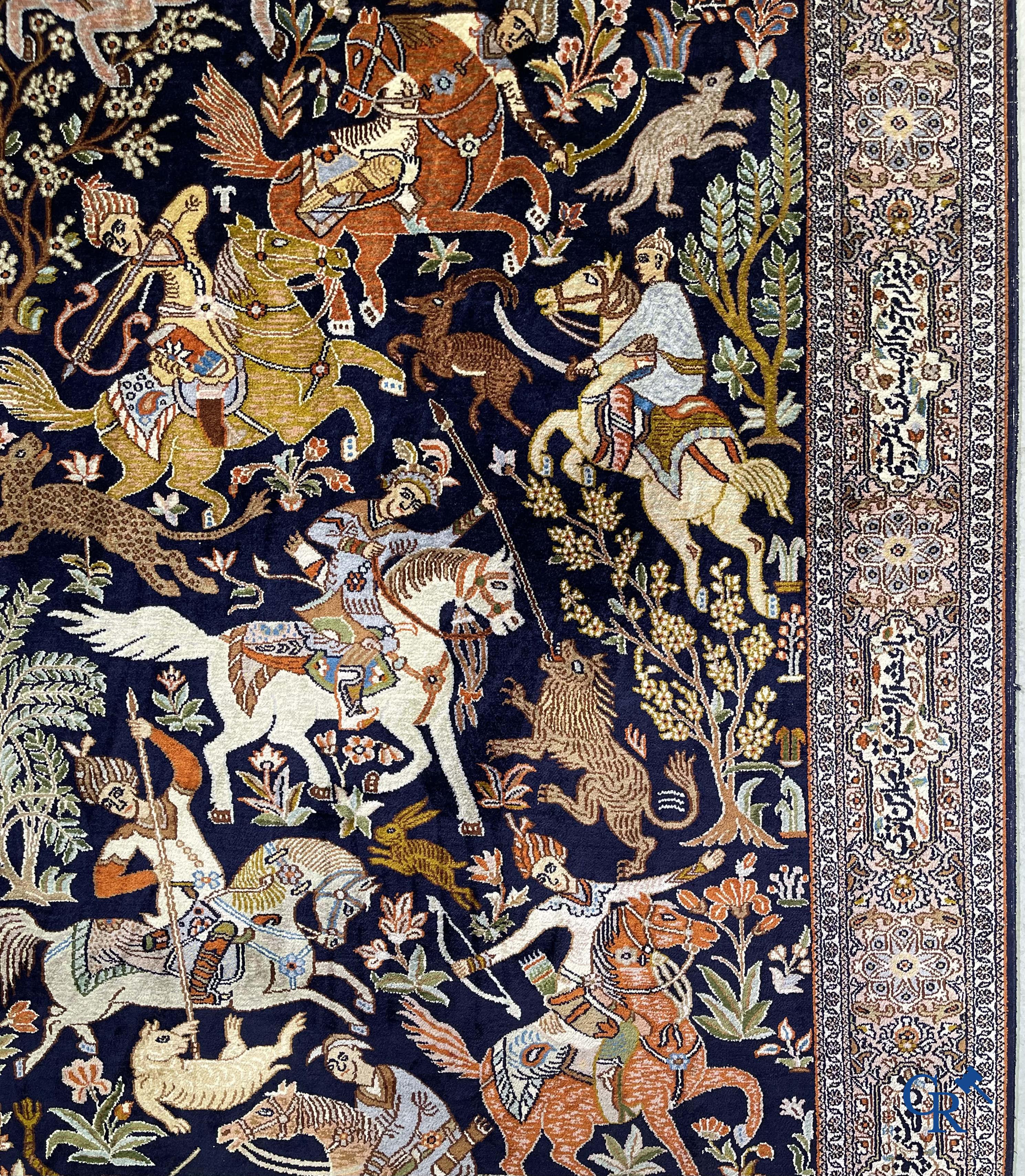 Oriental rugs. Iran. A finely hand-knotted Persian rug in wool and silk with hunters on horseback and inscriptions.