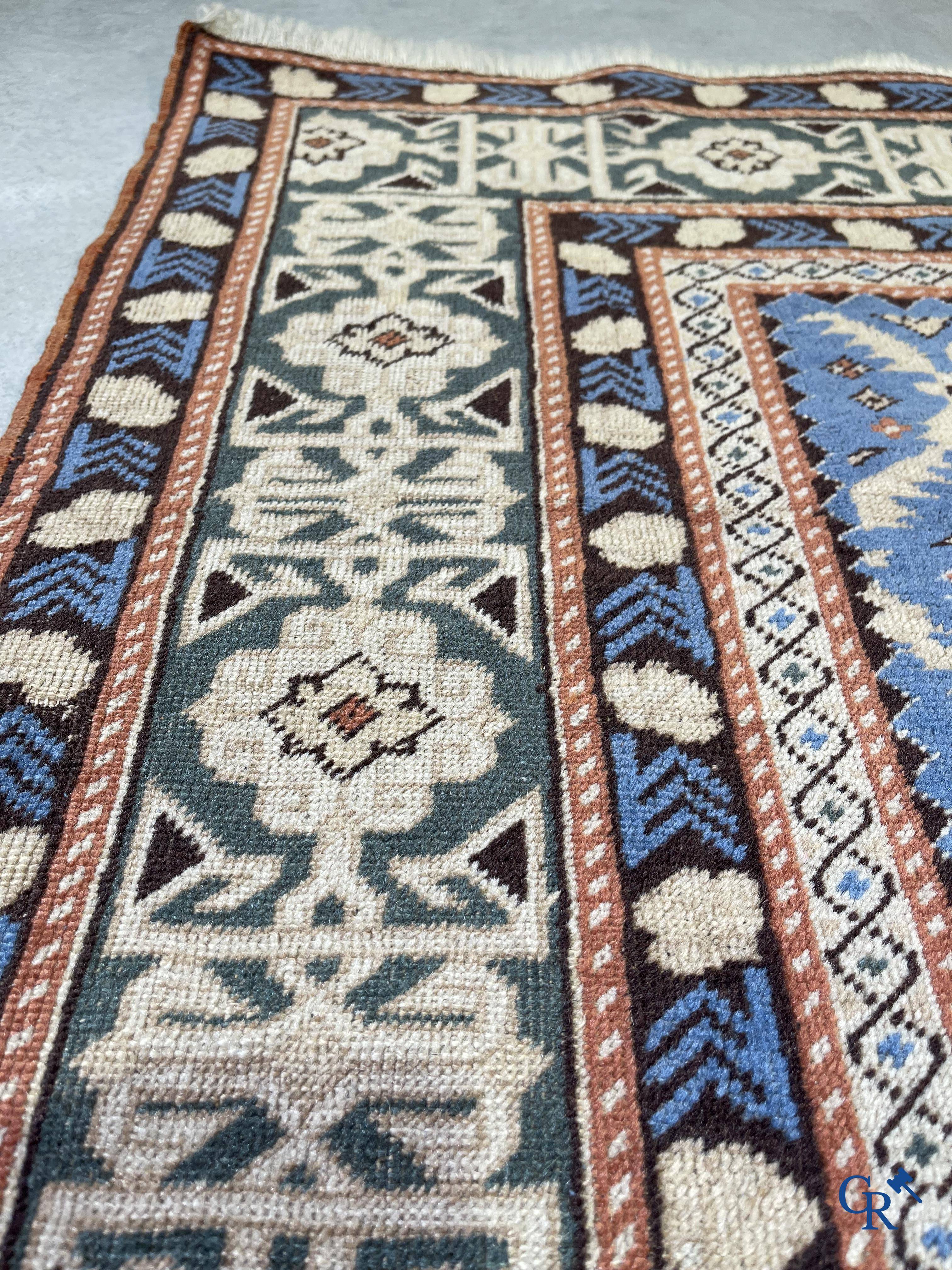 Antique Oriental carpets, an antique Dagestan carpet with motifs on a blue background.