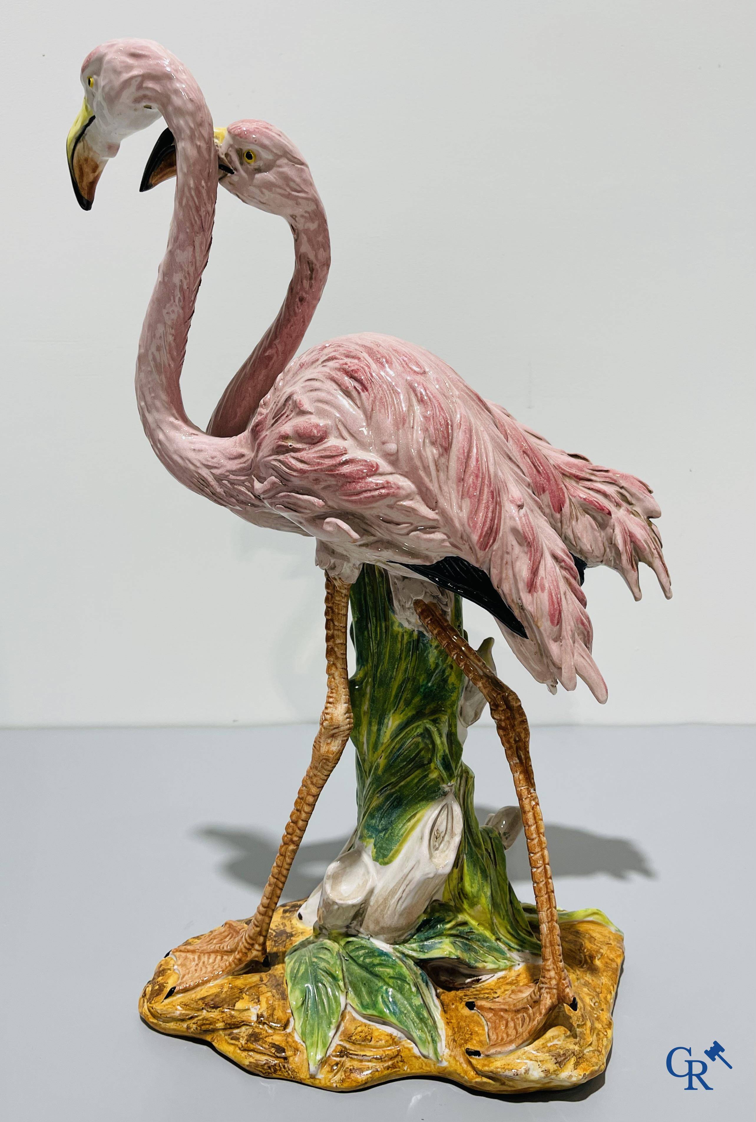 Een paar flamingo's in majolica in de stijl van Massier.