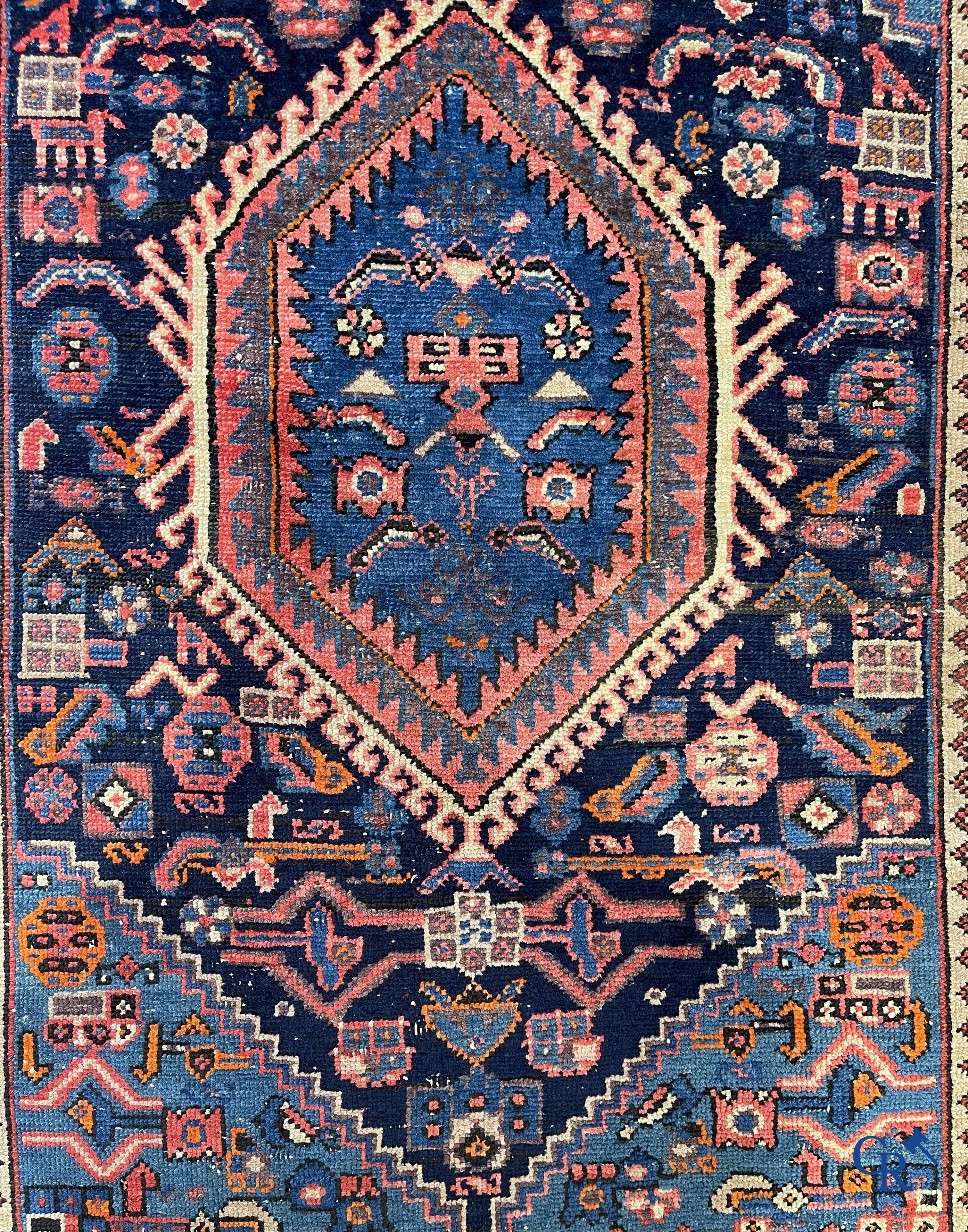 Antique Oriental carpets, an antique hand-knotted carpet with motifs on a blue background.