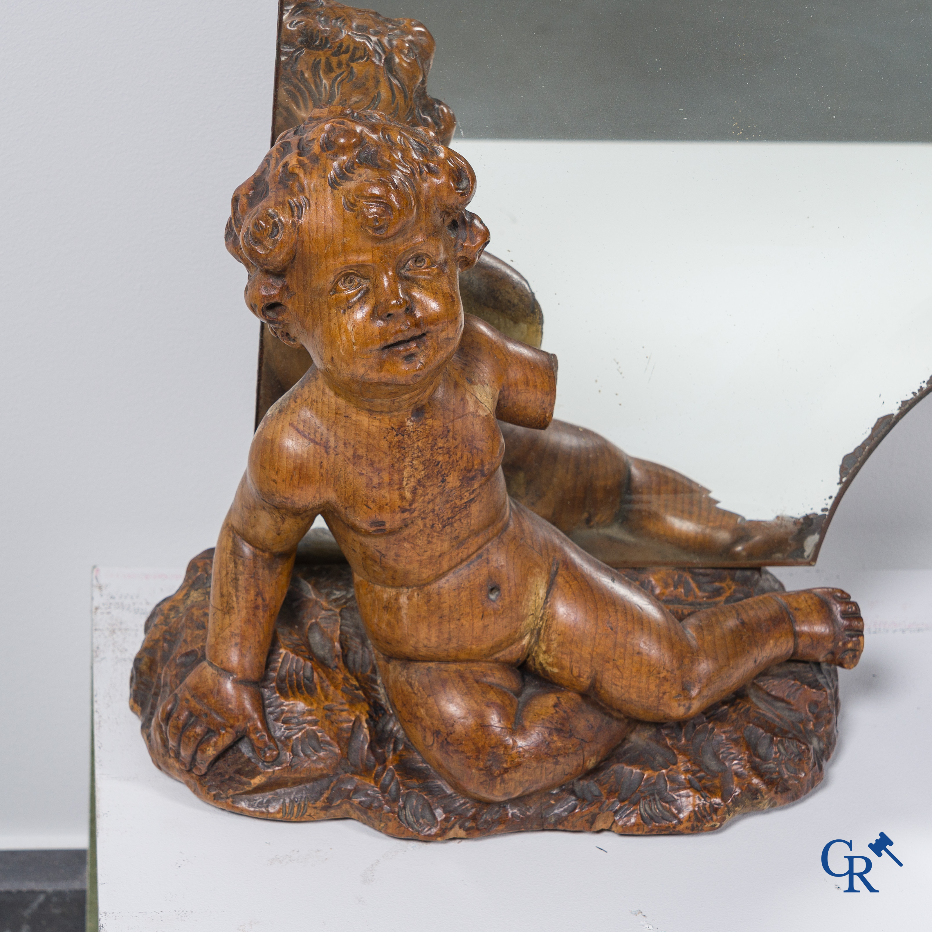 Un grand miroir entouré de 6 putti en bois sculpté. Vers 1900.