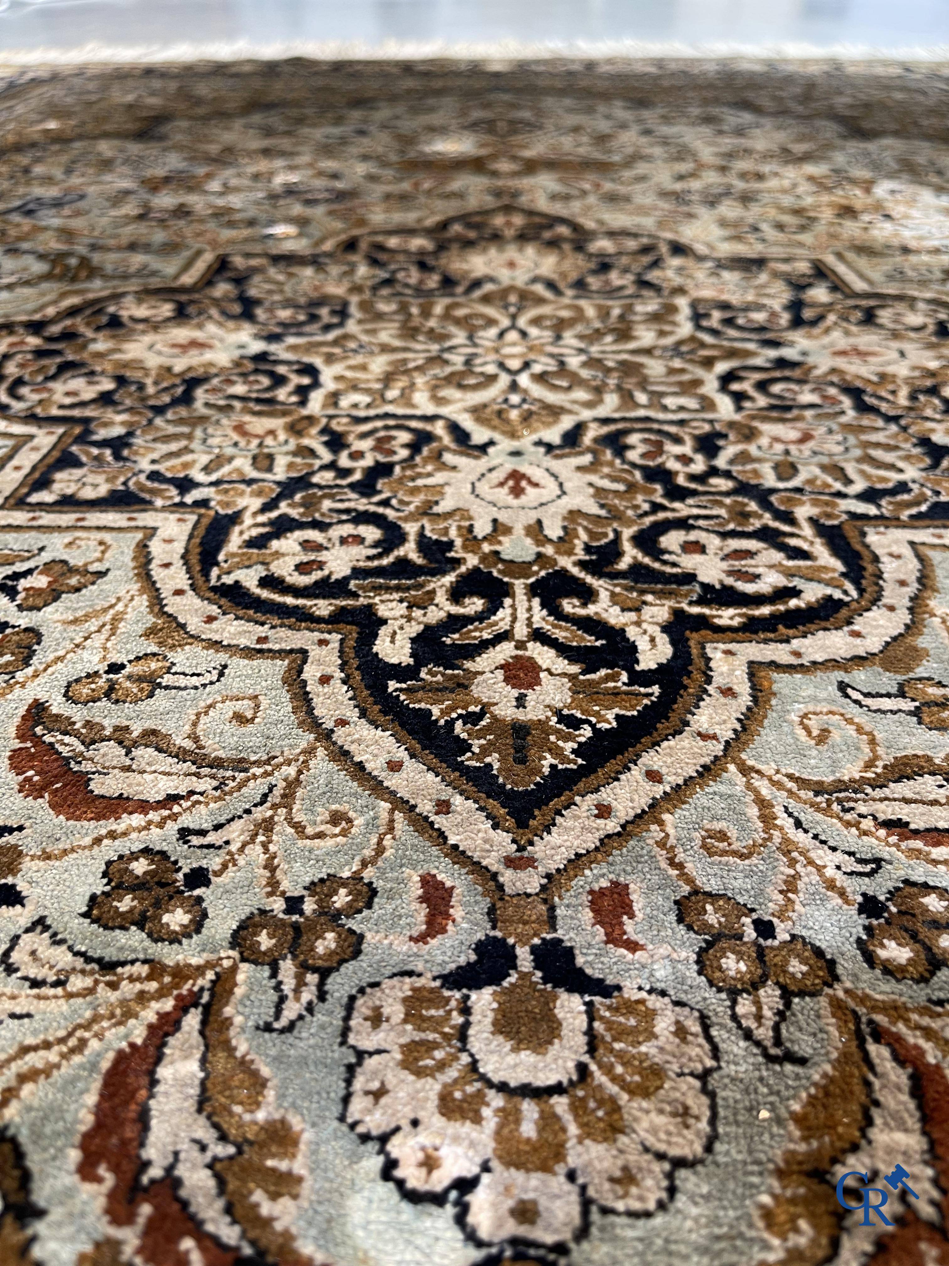 Tapis d'Orient. Un tapis en soie finement noué à la main avec un décor floral.