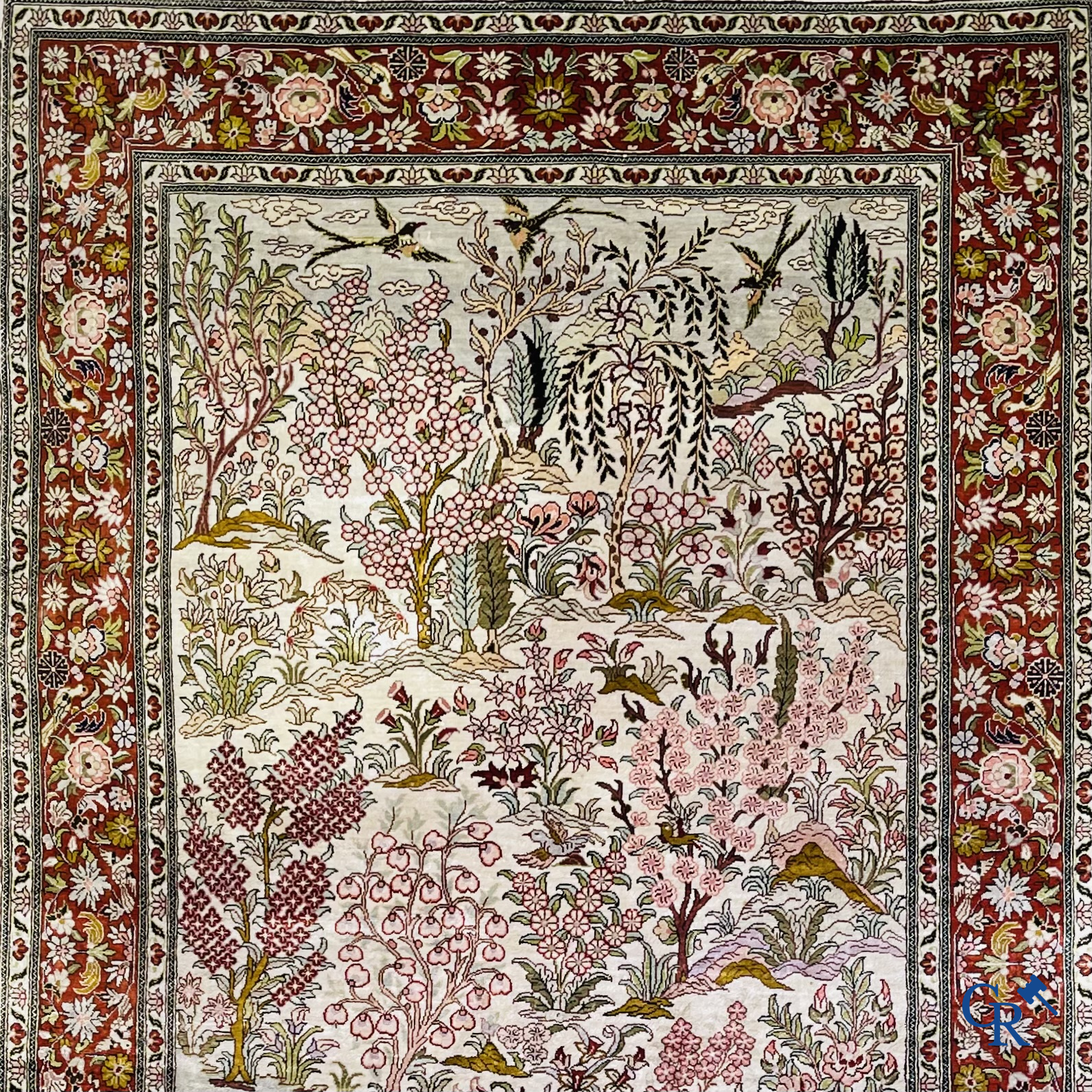 Tapis d'Orient: Un tapis en soie finement noué à la main avec des oiseaux aquatiques dans un paysage sur fond floral.