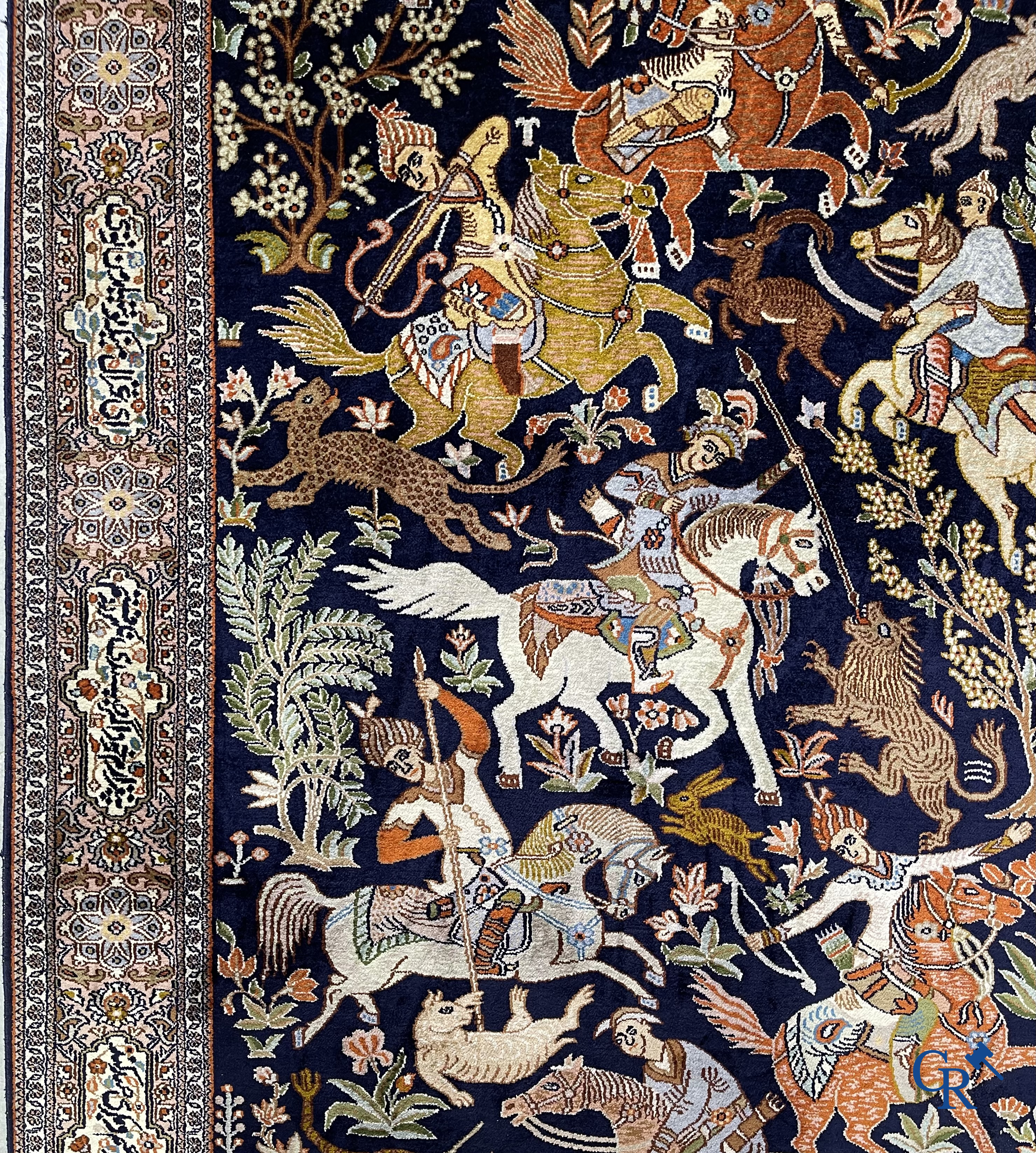 Oriental rugs. Iran. A finely hand-knotted Persian rug in wool and silk with hunters on horseback and inscriptions.